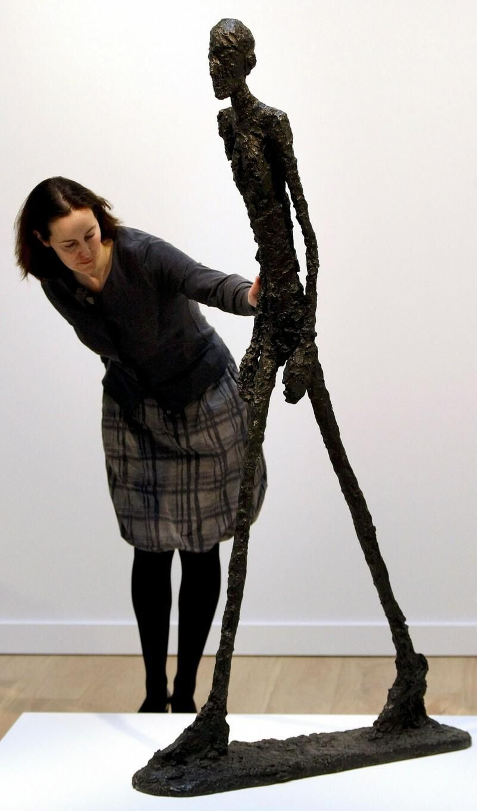 Una mujer contempla la mítica escultura en una exposición.