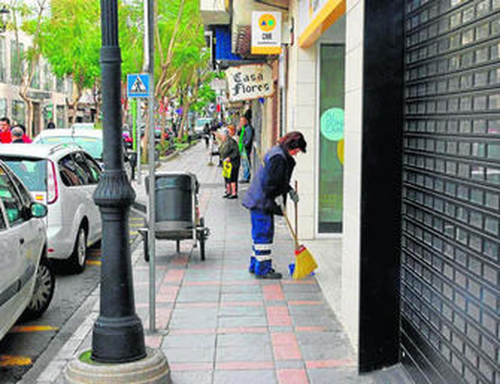 Una trabajadora limpiando una calle del municipio.