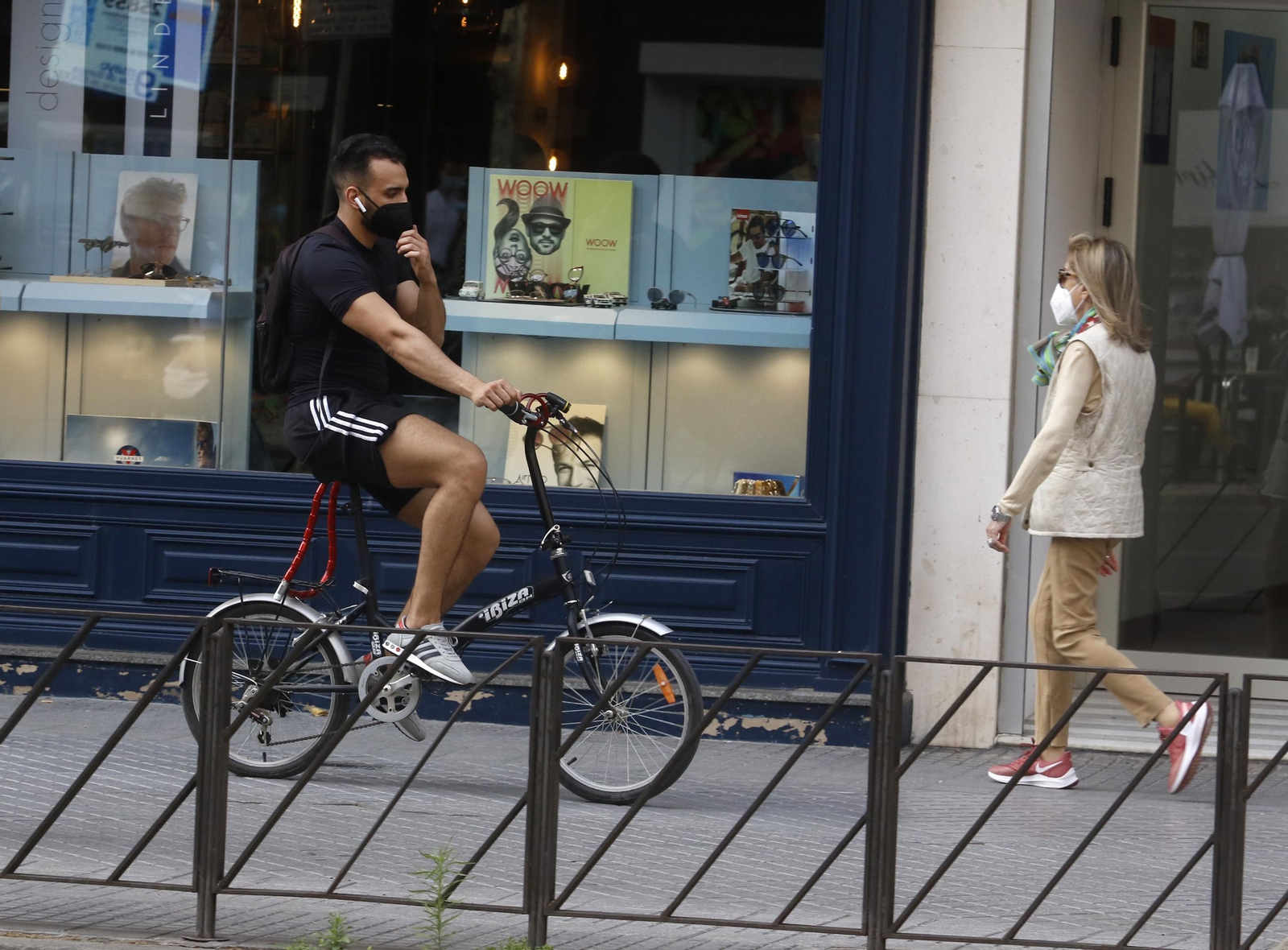 Un ciclista y un peatón comparten una vía en el centro de Córdoba.