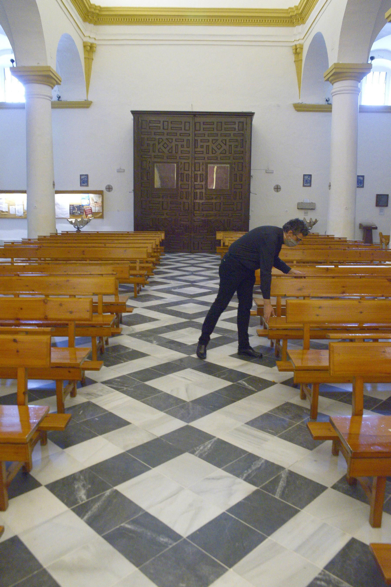 Una persona coloca los bancos en el interior de la parroquia de Nuestra Señora de la Palma, en Algeciras.