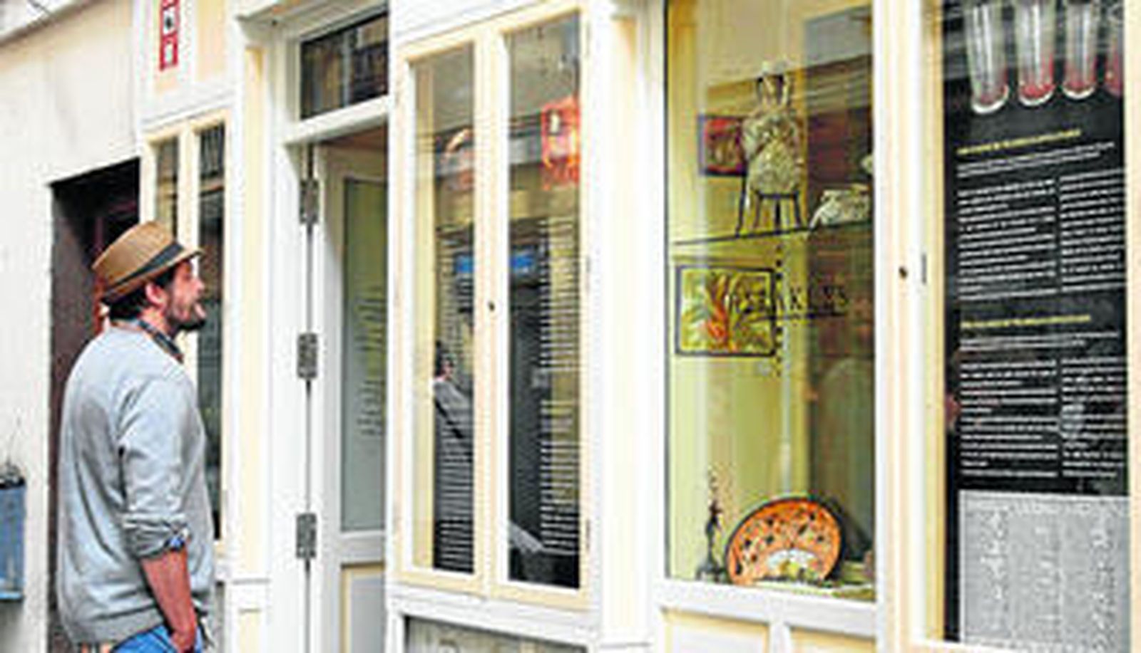Un paseante contempla la fachada de carpintería de la tienda Herakles, situada en la calle Pelota.