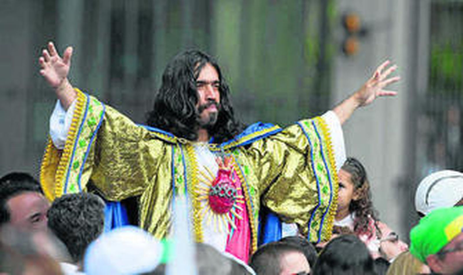 Un fiel caracterizado como el Sagrado Corazón de Jesús escucha al Papa.