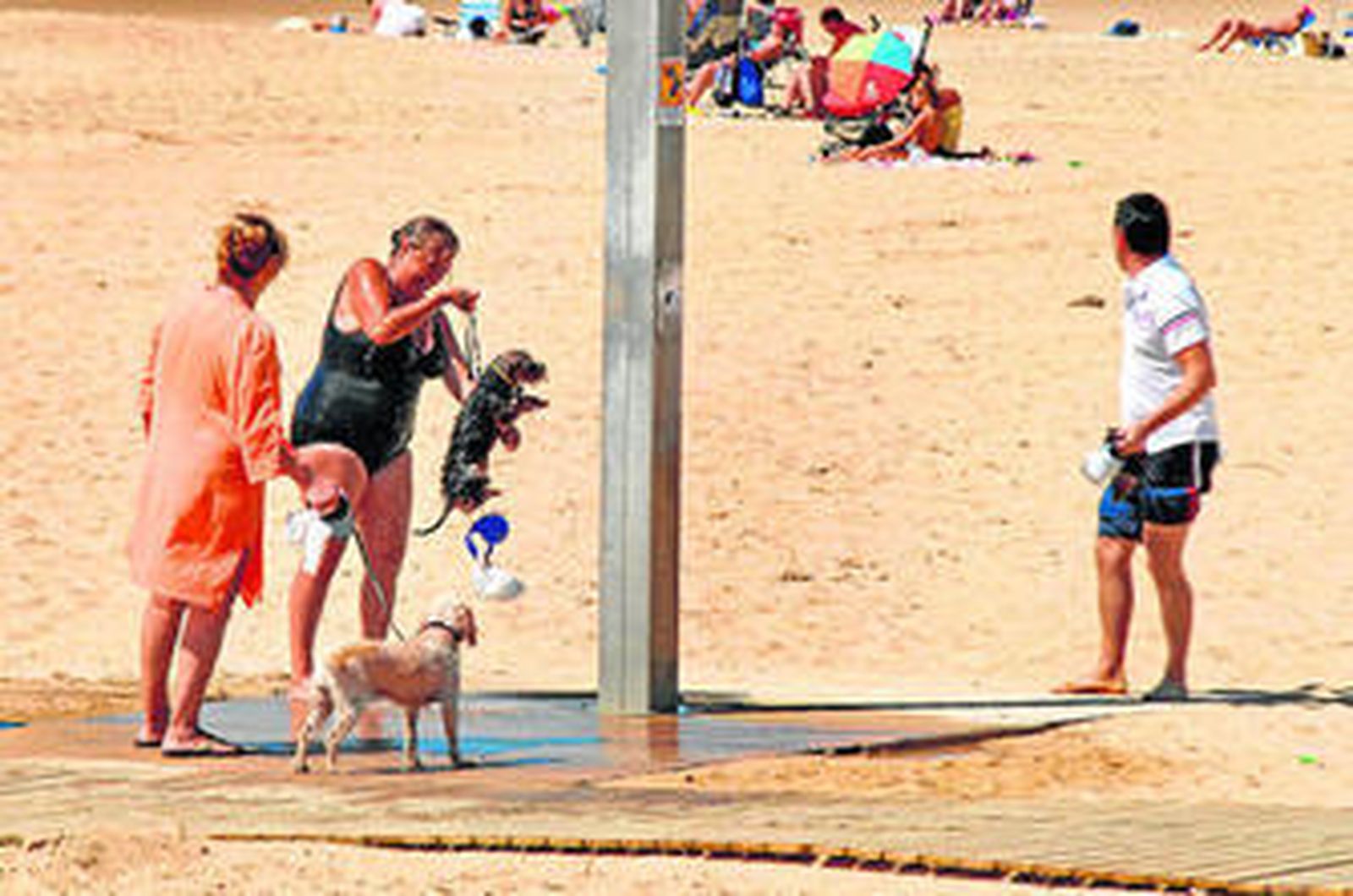 Dos mujeres con sus perros, en la playa de La Sal, en Casares.