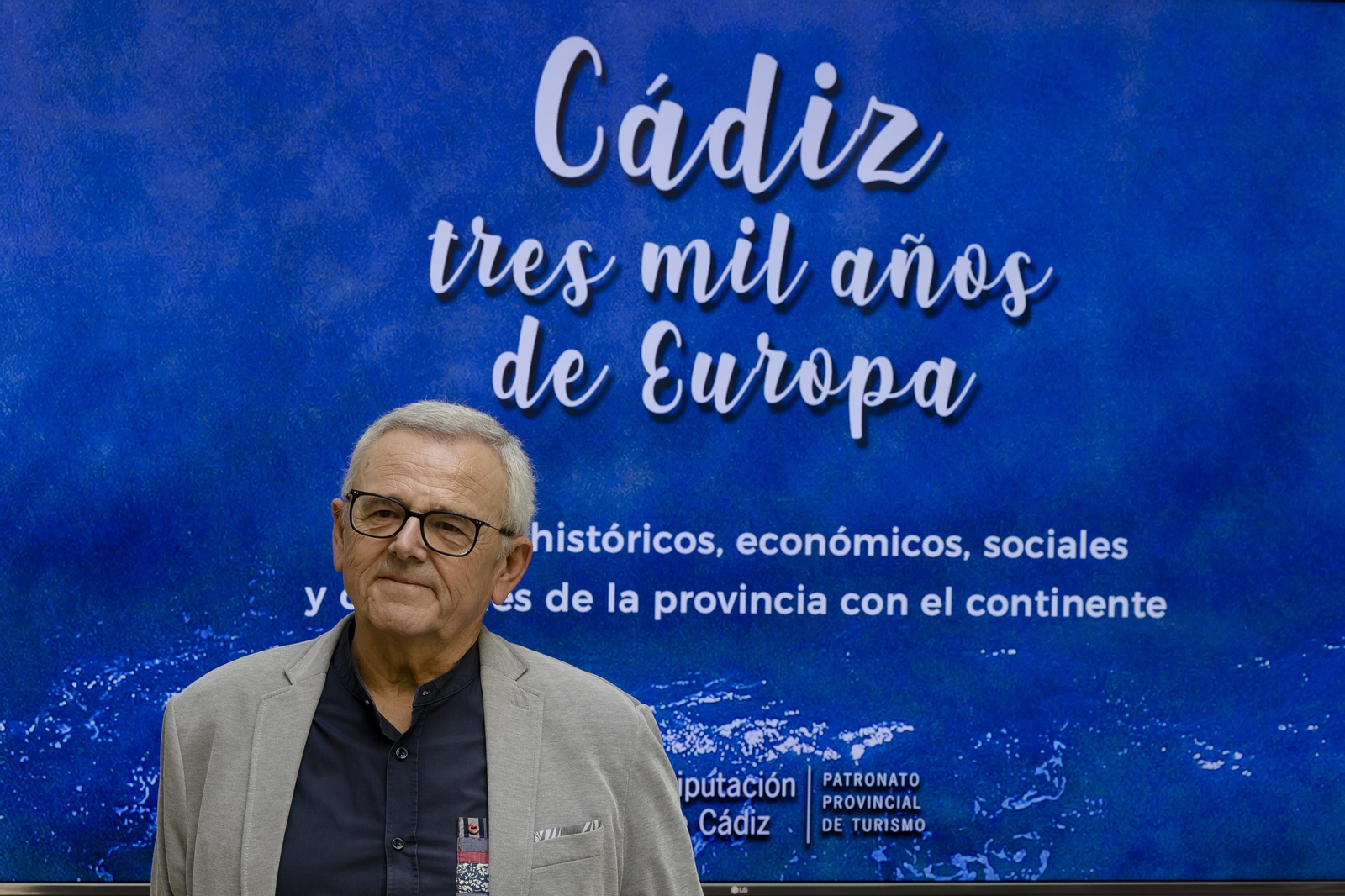 Manuel Muñoz Fossati ante el cartel promocional de la guía editada por la Diputación Provincial.