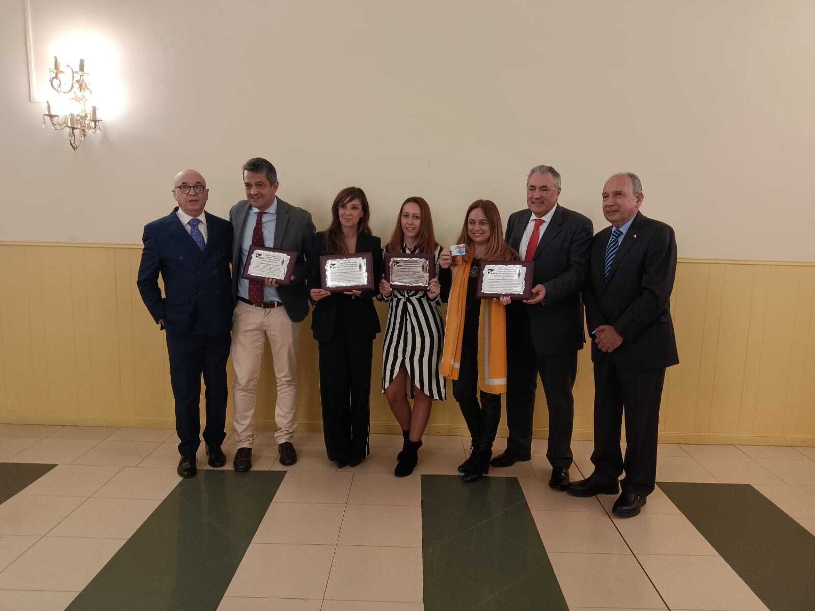 La periodista de Diario de Sevilla, Cristina Valdivieso, en el centro, junto al resto de premiados y el presidente de la AATH y el doctor José Pérez Bernal, en los extremos.
