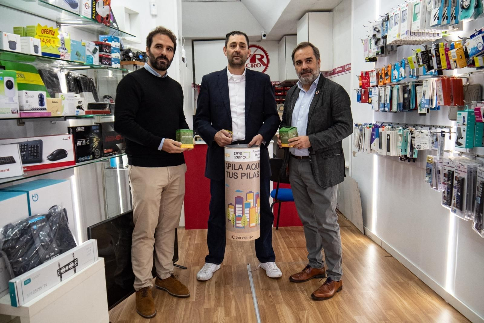 Imagen de la entrega de un cubo de reciclaje de pilas a un comercio de Granada