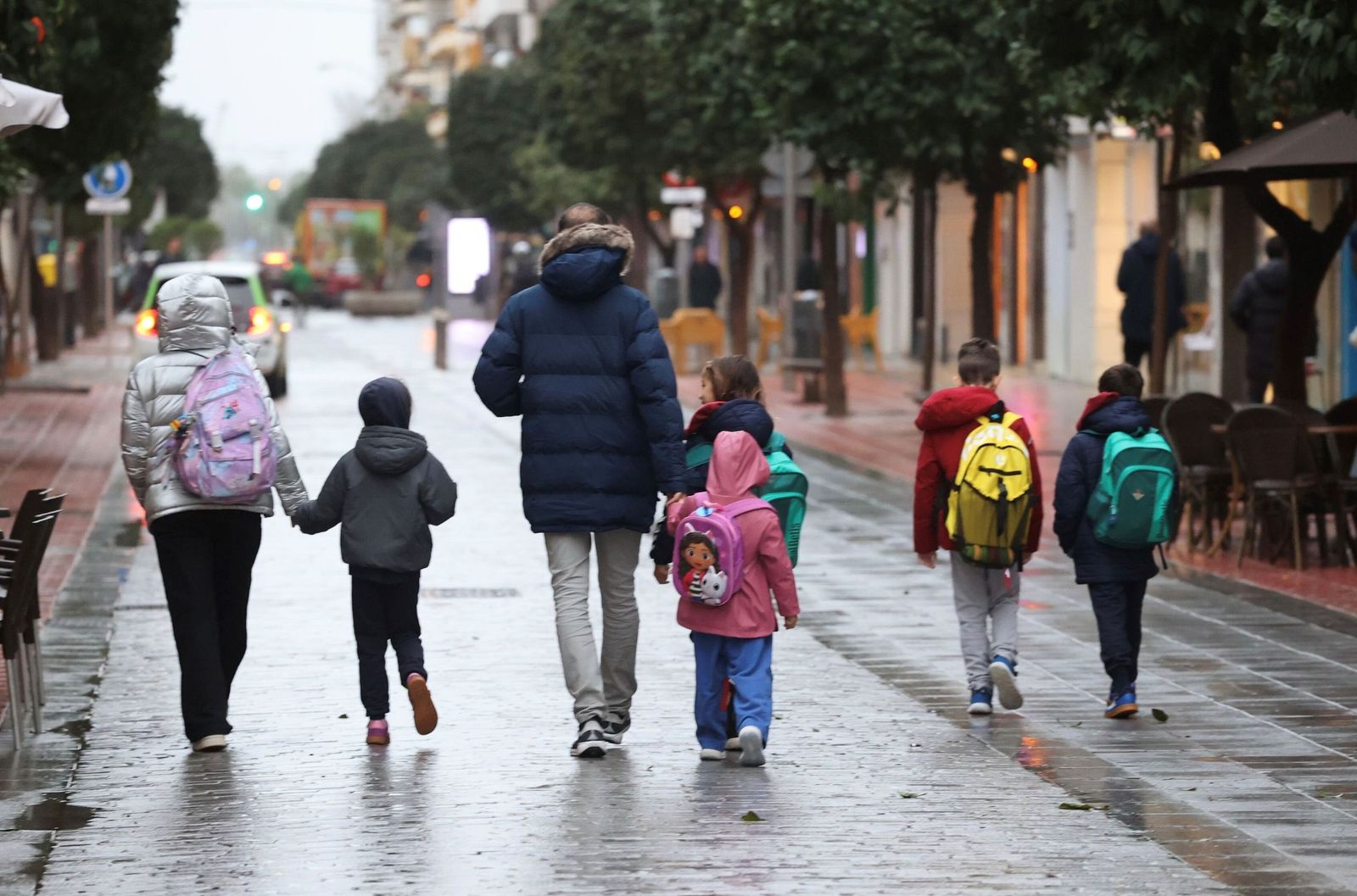 Una familia con varios miembros caminan hacia el colegio, en el barrio de Los Remedios.
