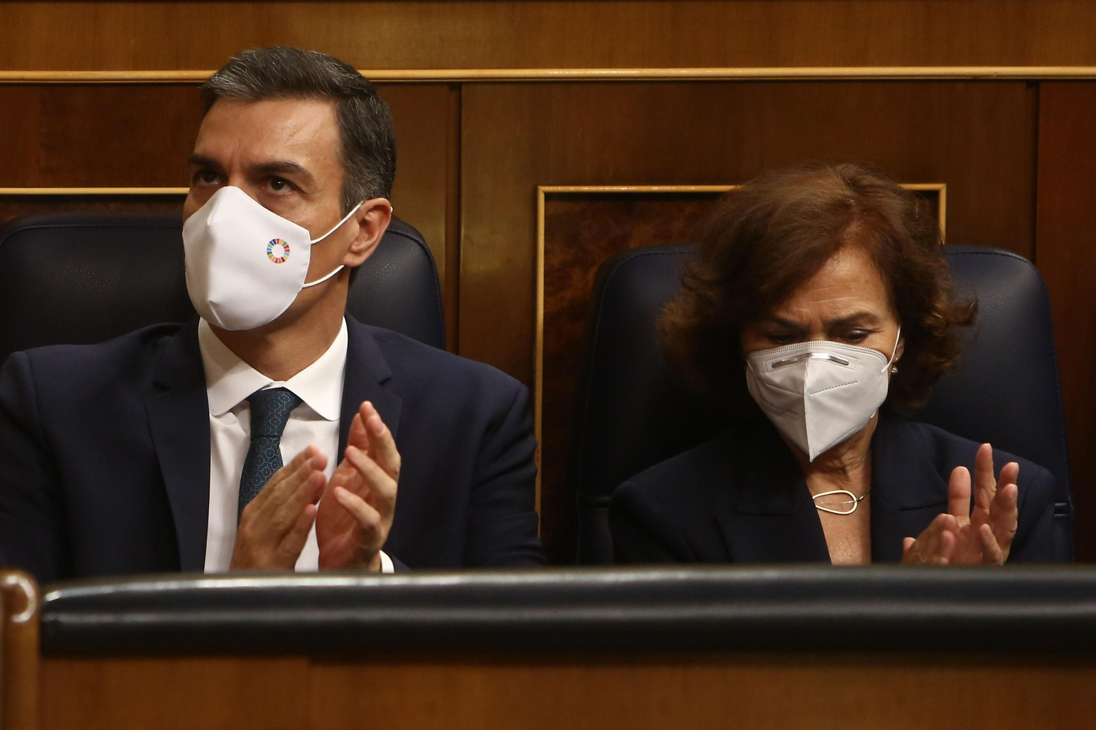 El presidente del Gobierno, Pedro Sánchez, y la vicepresidenta primera del Gobierno, Carmen Calvo, aplauden durante la sesión plenaria de este jueves
