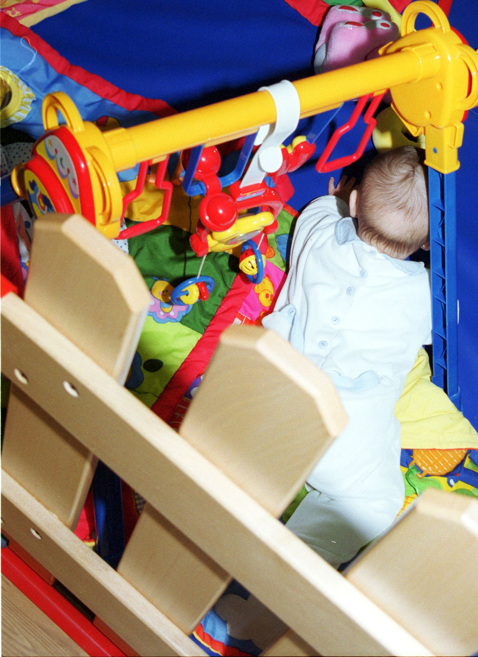 Un bebé acogida en un centro de protección de menores juega al cuidado de los educadores que se han hecho cargo de él.