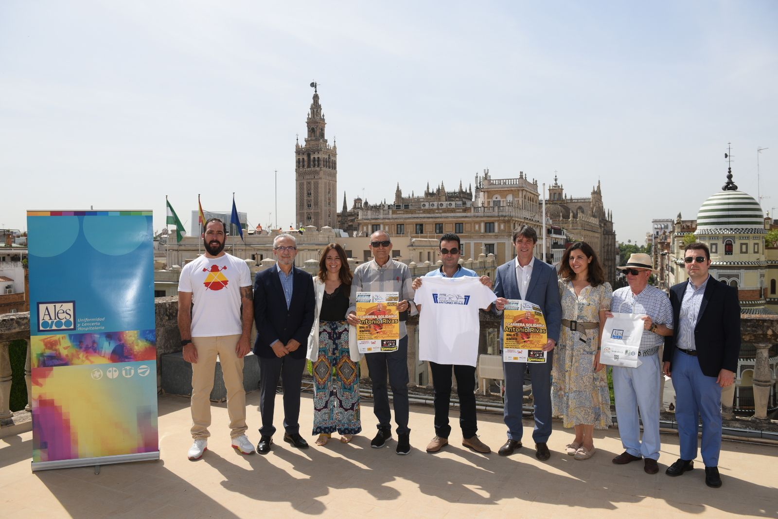 Presentación de la I Carrera Popular Antonio Rivas, donde aparece el homenajeado, David Guevara, Juan Manuel Flores, miembros del club Amate Runners y la Asociación Grupo Giralda y patrocinadores.