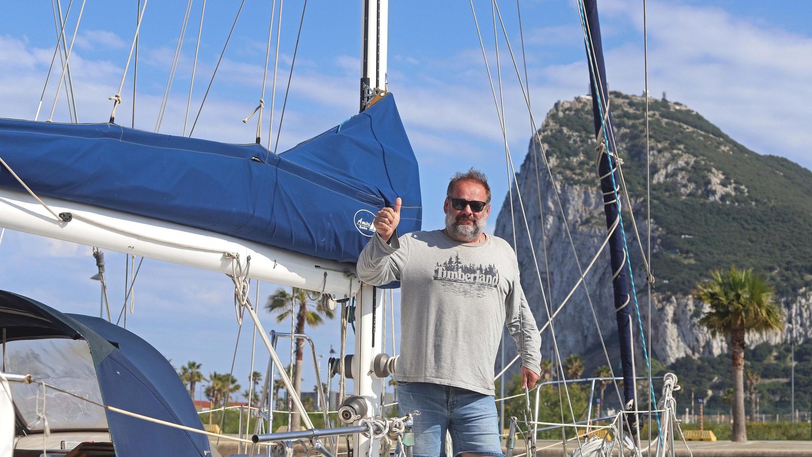 Paul Beerturner a bordo del velero 'Sunrise', en Alcaidesa Marina, con Gibraltar al fondo.