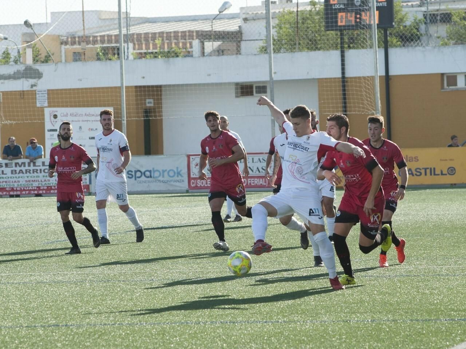 Un jugador del Antoniano controla el balón en presencia de varios jugadores del Puente Genil.