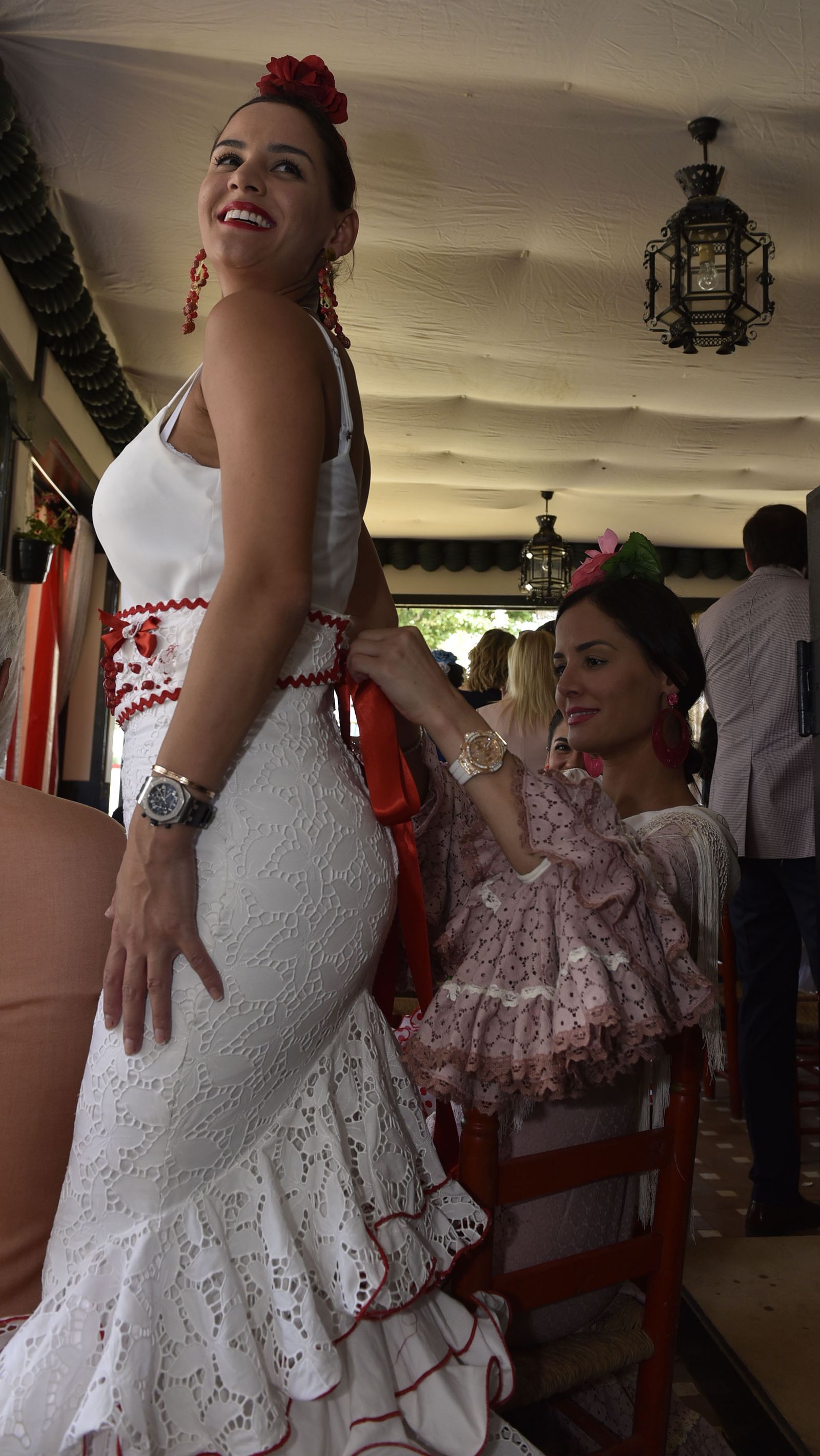 Retoques de última hora en el traje de flamenca dentro de una de las casetas.