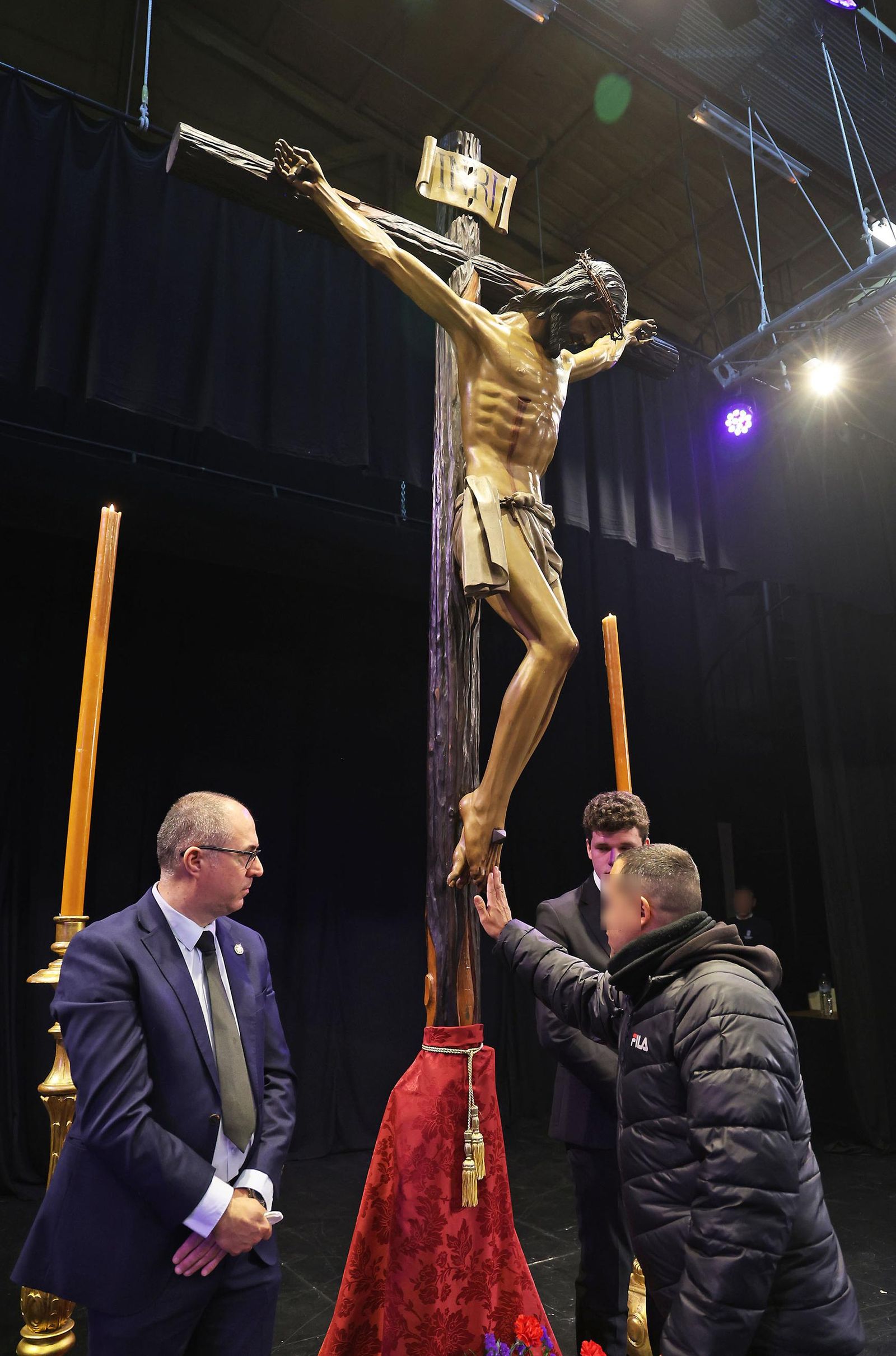 Un interno se acerca al Cristo.