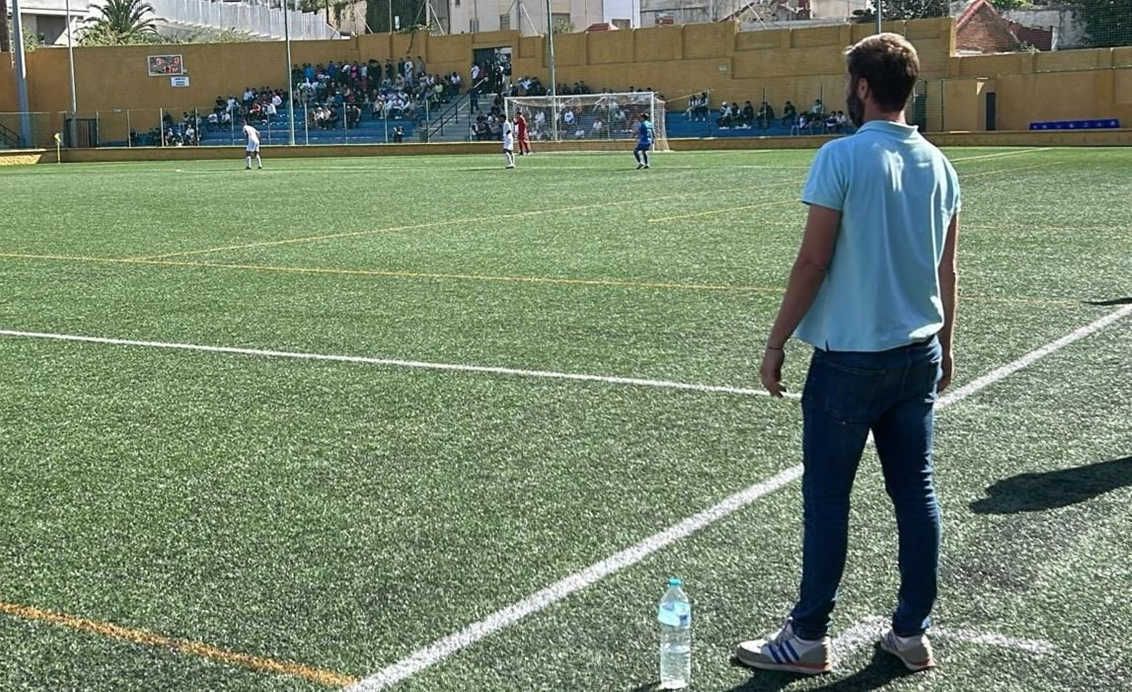 David Sánchez sigue atento el partido con la afición azulina al fondo.