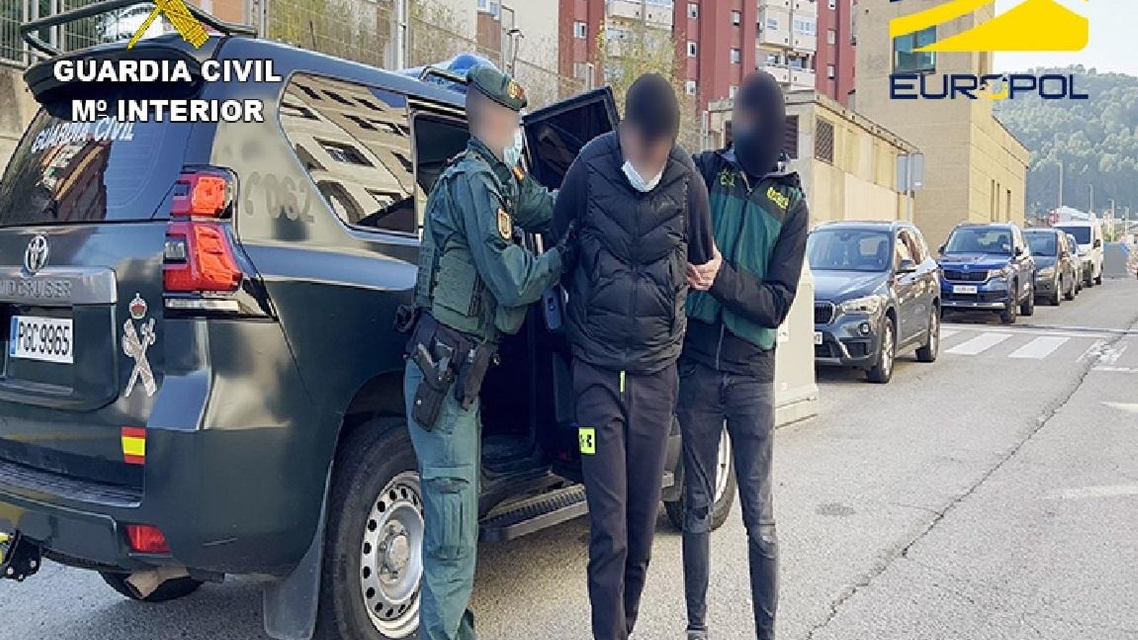 Dos agentes de la Guardia Civil conducen a uno de los detenidos.