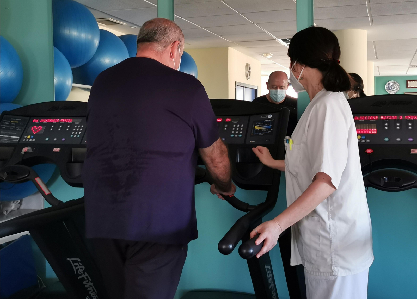 Una fisioterapeuta del servicio sanitario público andaluz junto a un paciente.