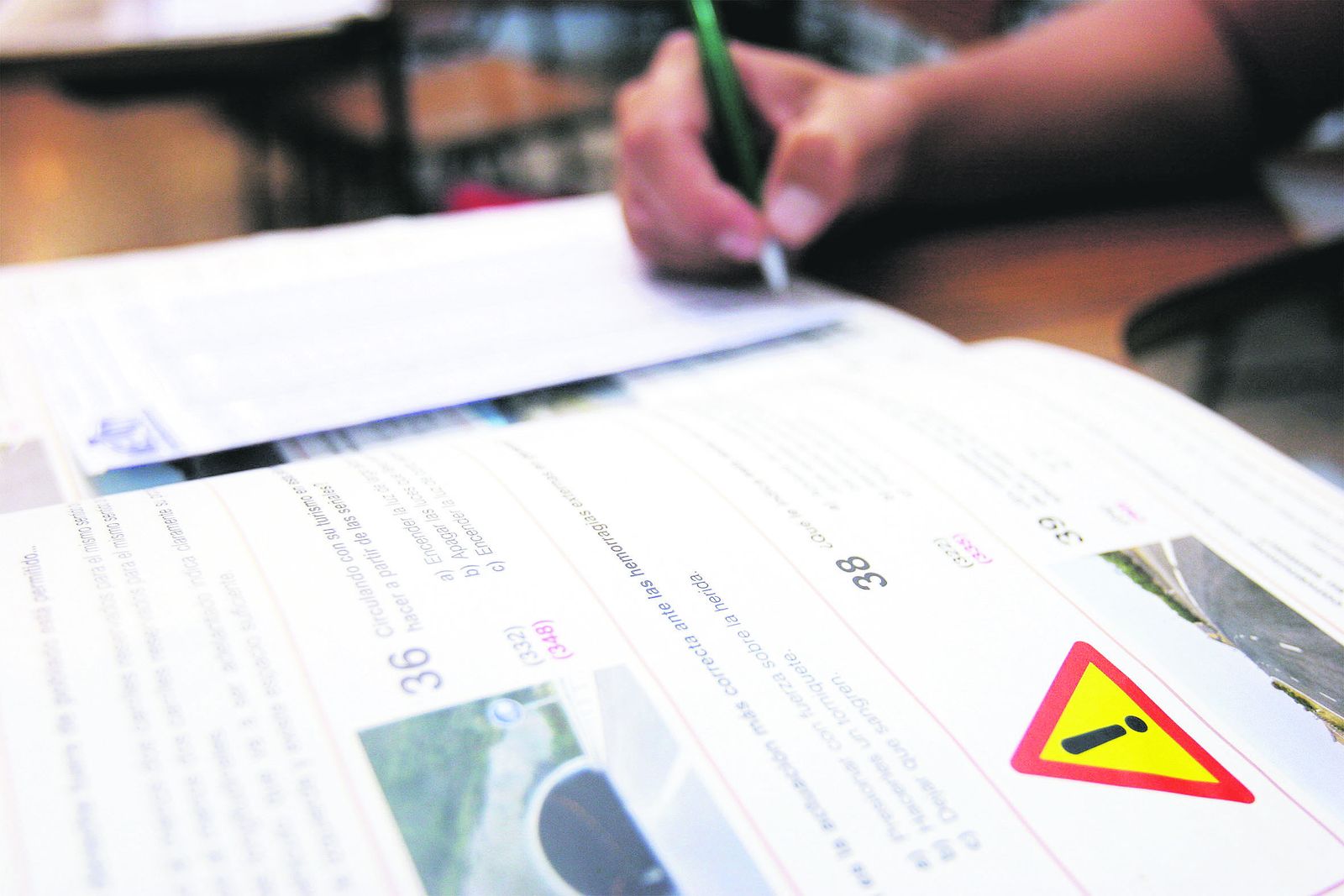Un alumno realiza unos test dentro de  las clases teóricas que recibe en el aula de  una autoescuela.