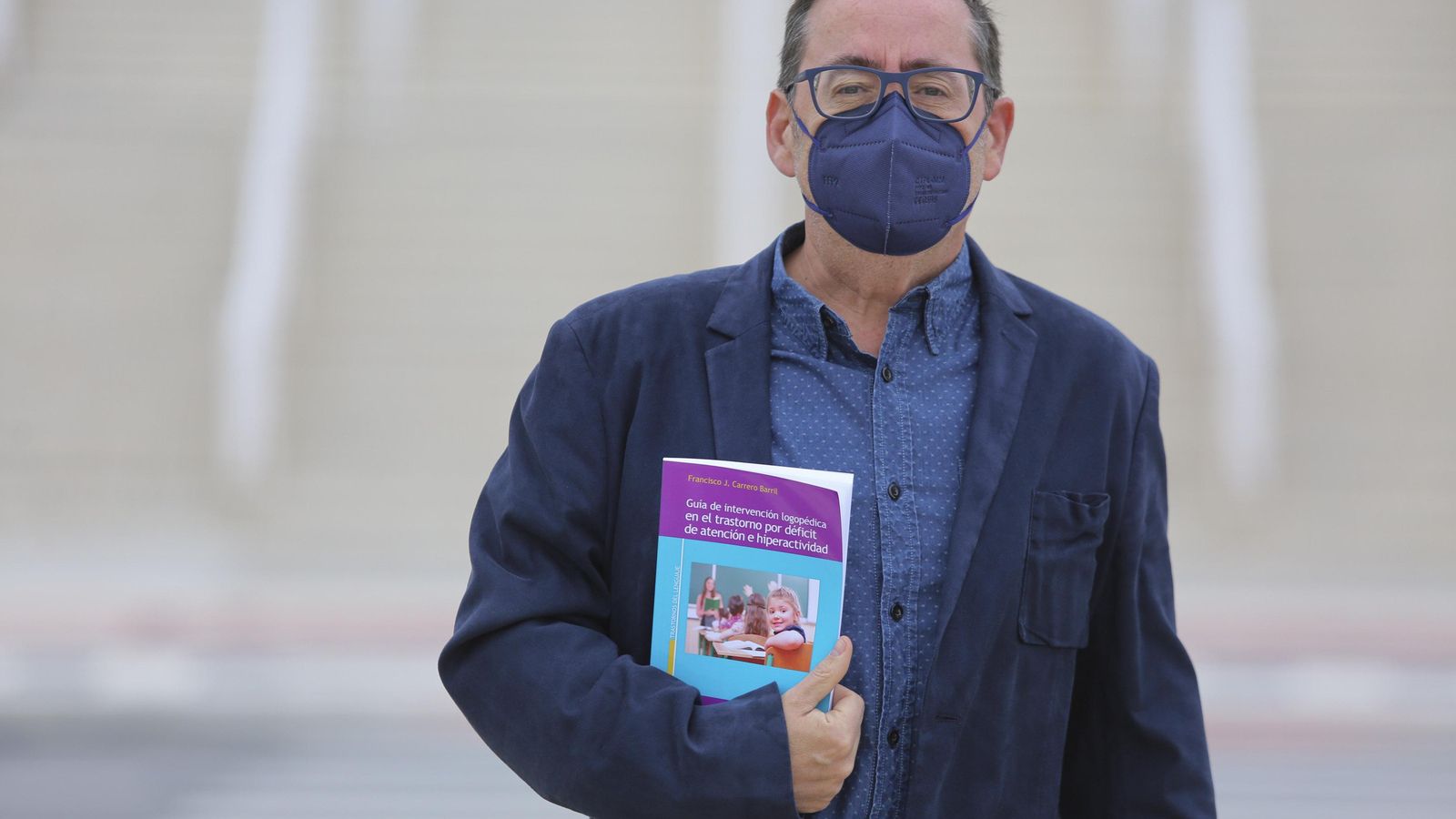 Carrero con su libro junto a la Facultad de Psicología y Logopedia.