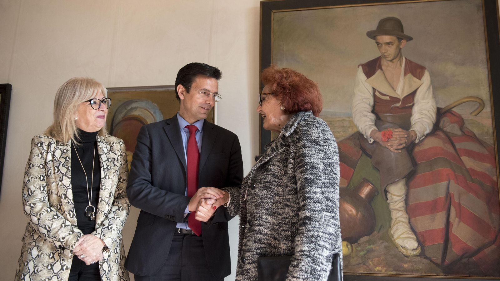 La sobrina del pintor junto al alcalde y la concejala de cultura posan frente a la obra 'Campesino'.