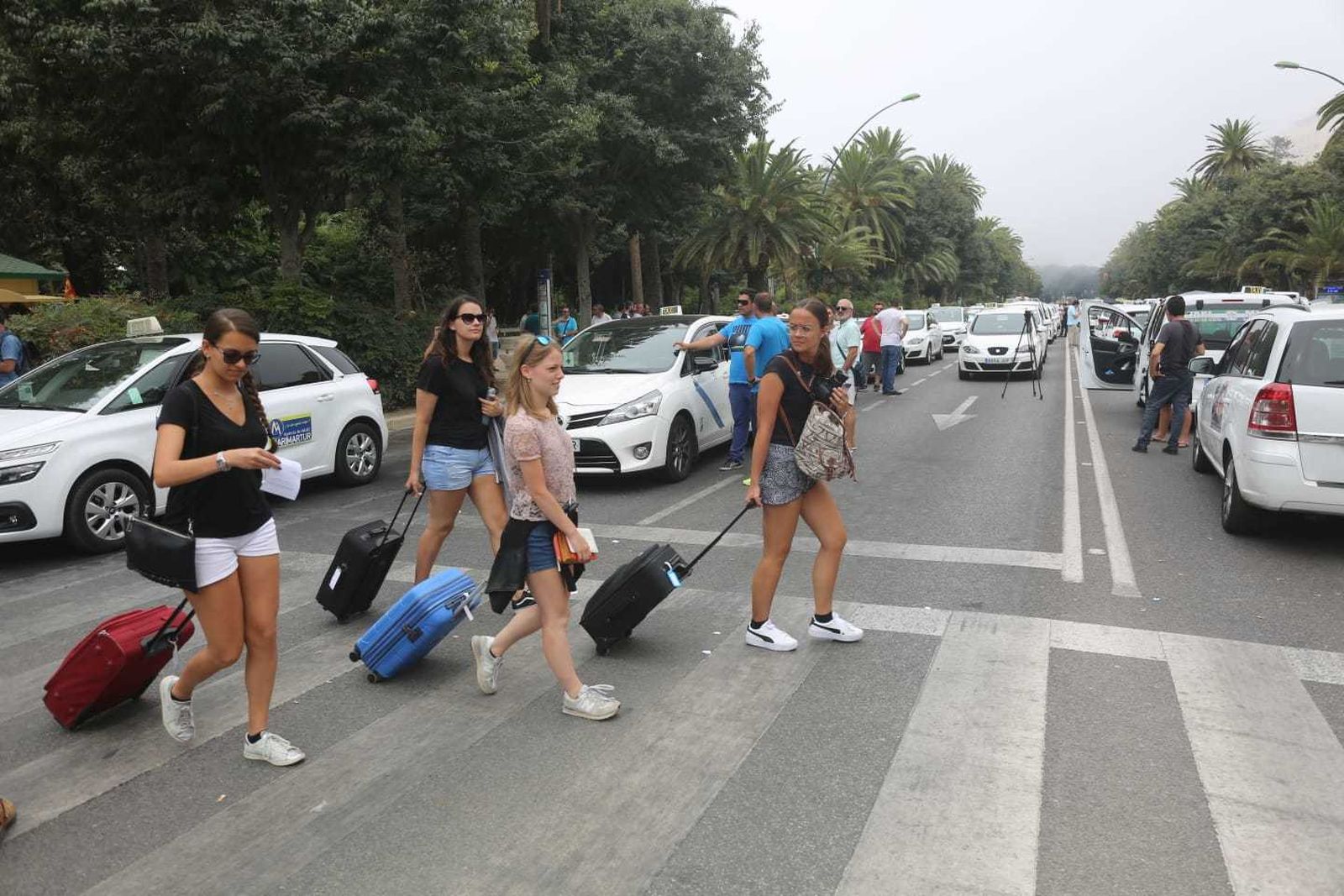Turistas circulan por el Paseo del Parque durante la acampada de los taxistas