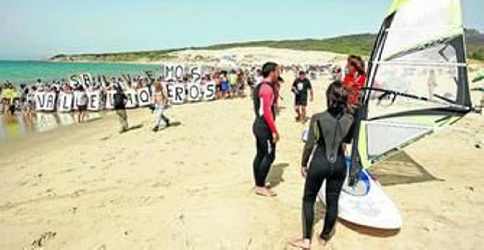 Los concentrados pasean con sus pancartas por la orilla de la playa de Valdevaqueros, ayer.