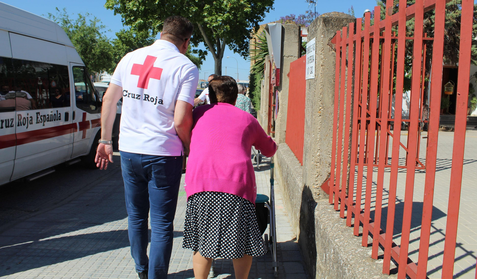 Un voluntario de Cruz Roja acompaña a una persona mayor.