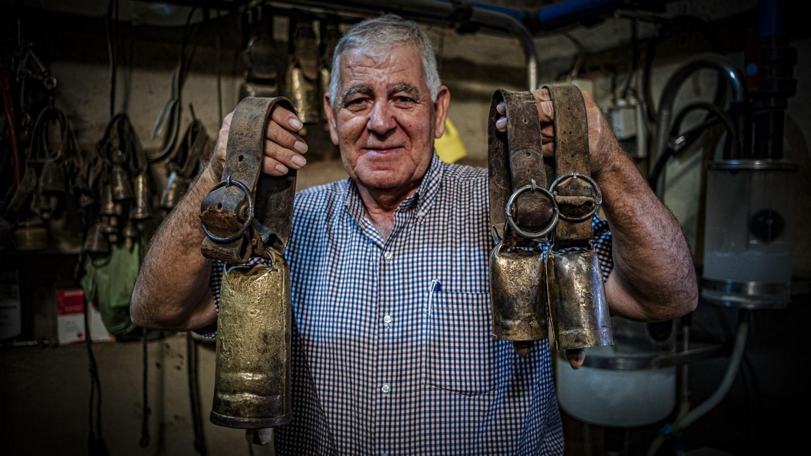 Pepe Millán posa en su explotación agrícola de Zahara de la Sierra con varios de los cencerros, alguno con más de cien años, que guarda como oro en paño.