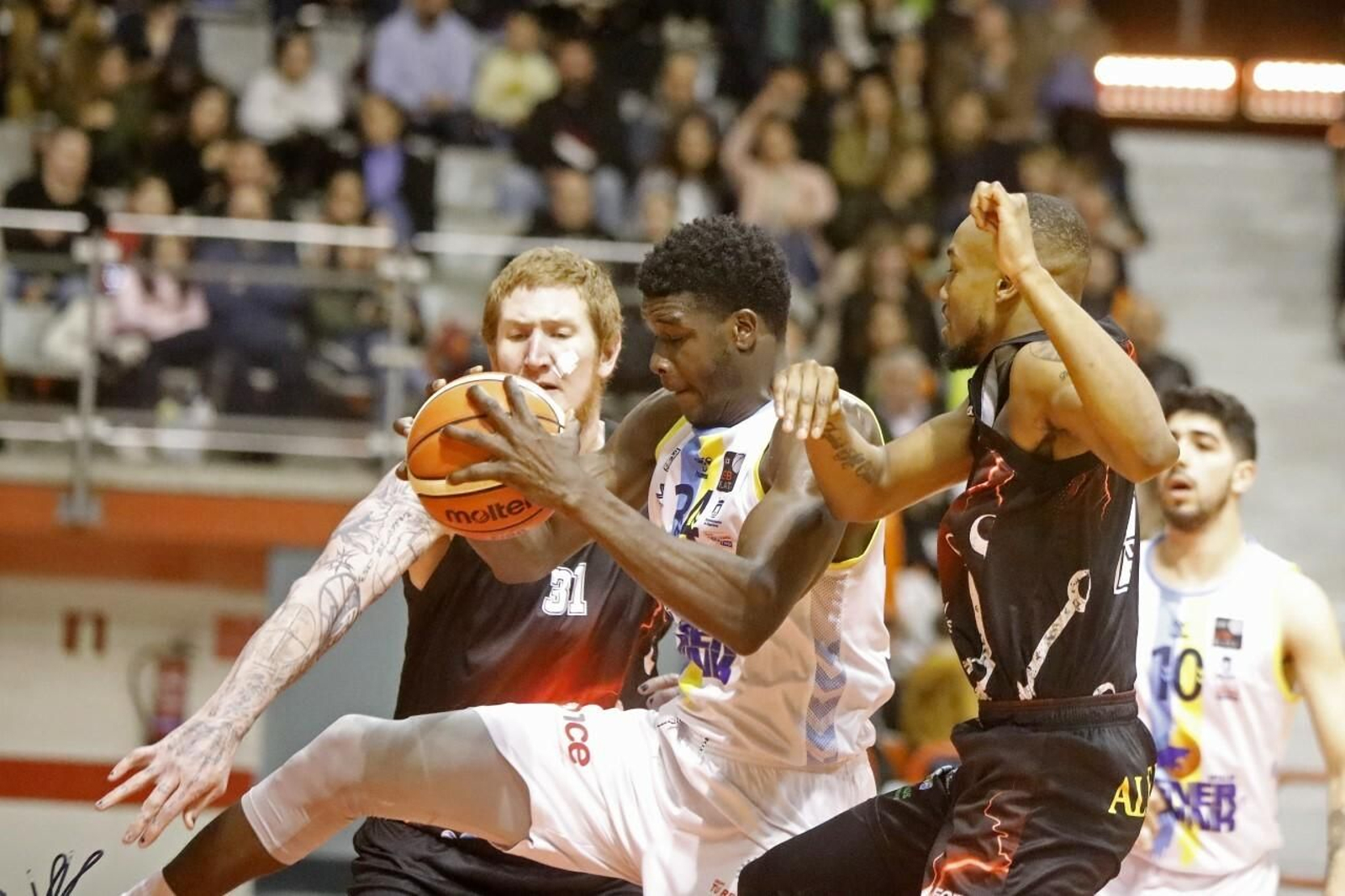 Mus Barro intenta anotar ante dos rivales.