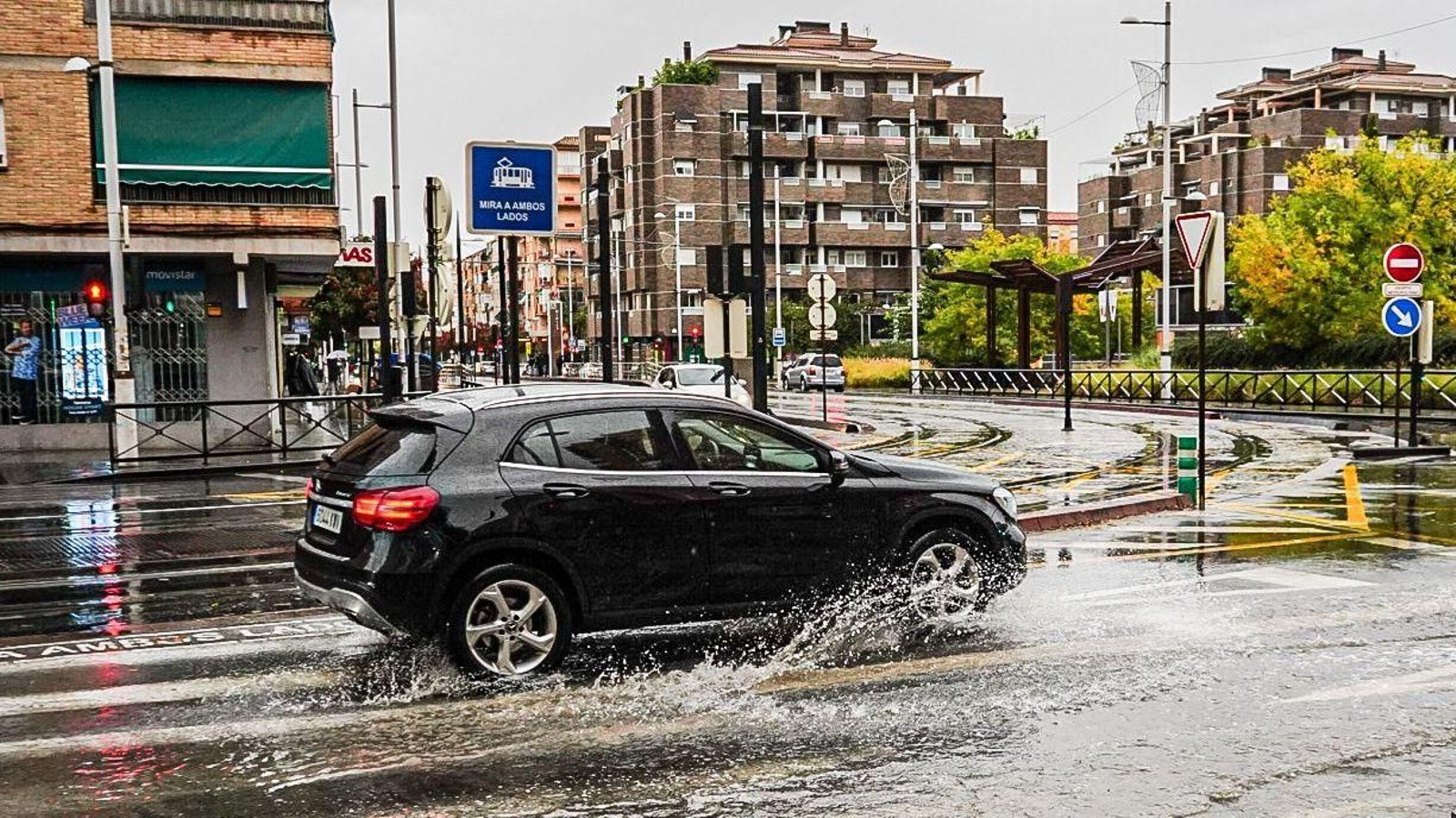 Un coche avanza por una zona inundada en Granada capital