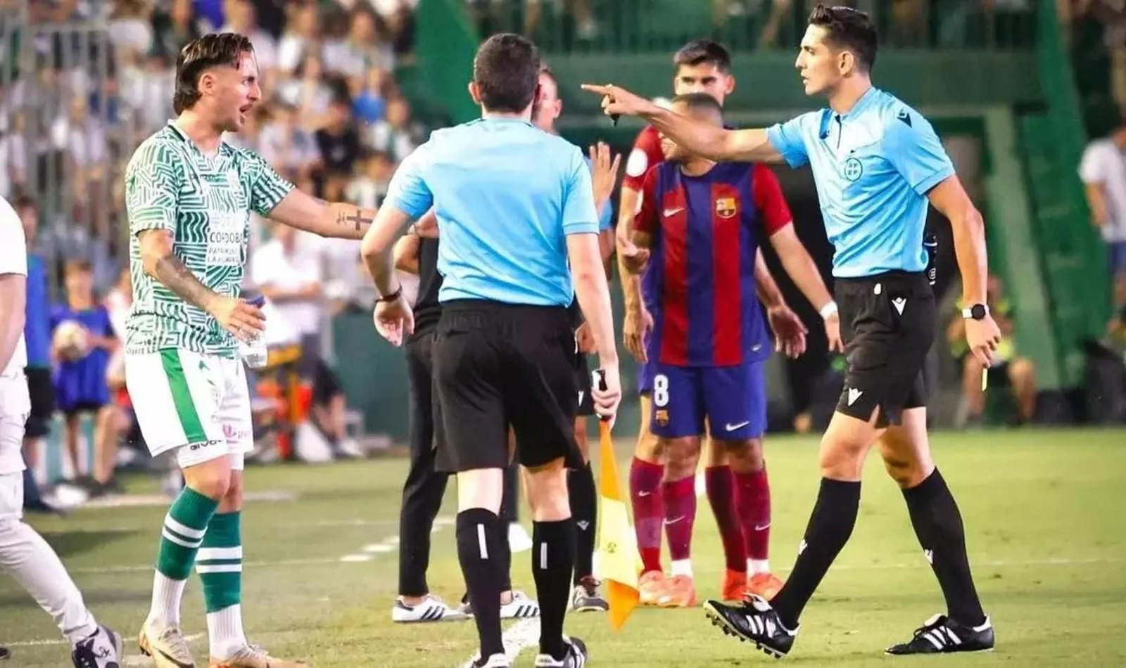 Árbitro se dirige a un jugador en un partido.