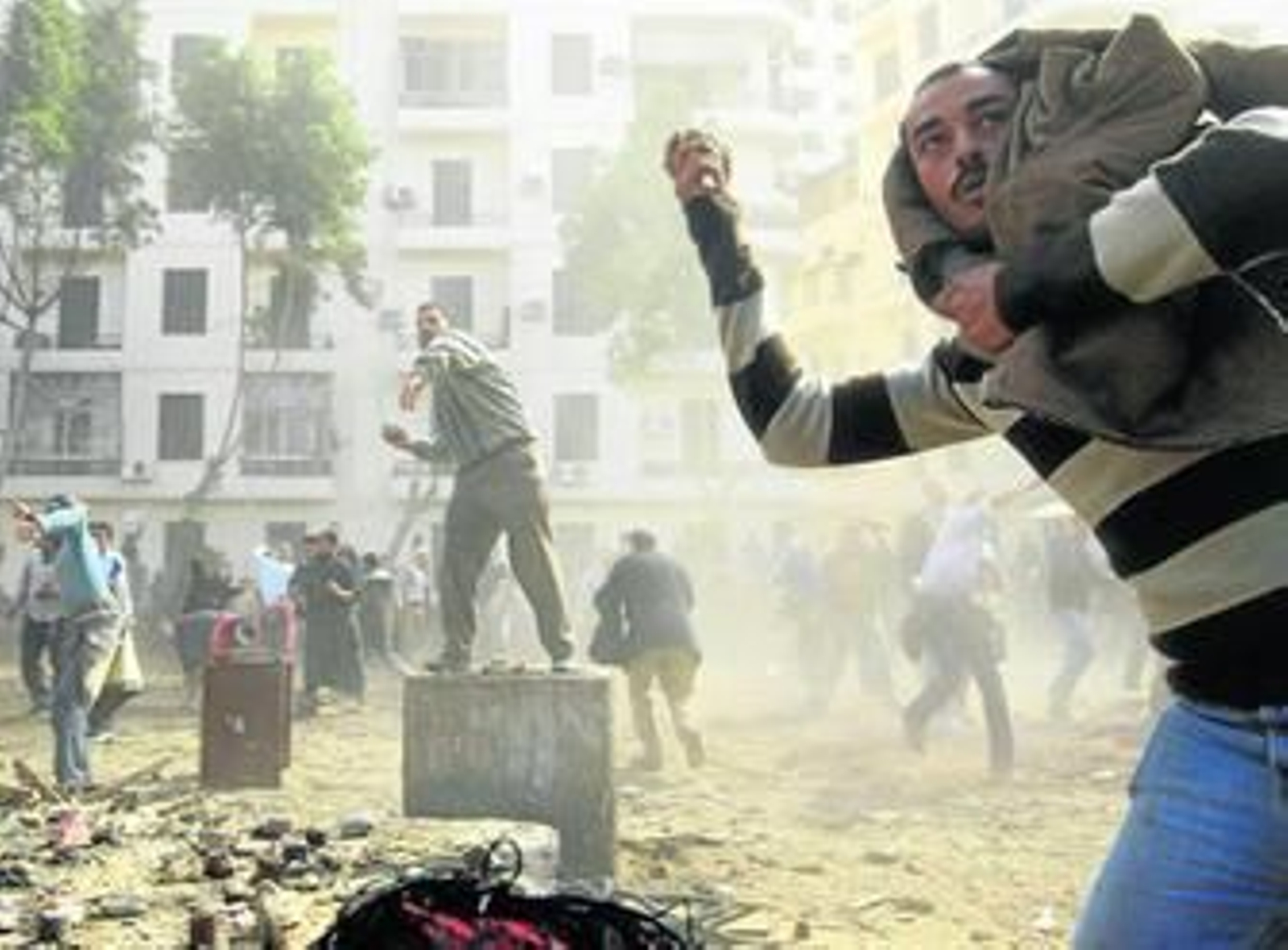 Opositores a Mubarak lanzan piedras durante los incidentes vividos ayer en el centro de El Cairo.