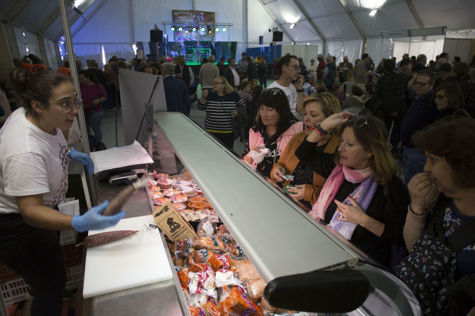 Visitantes adquieren productos en uno de los puestos del evento.