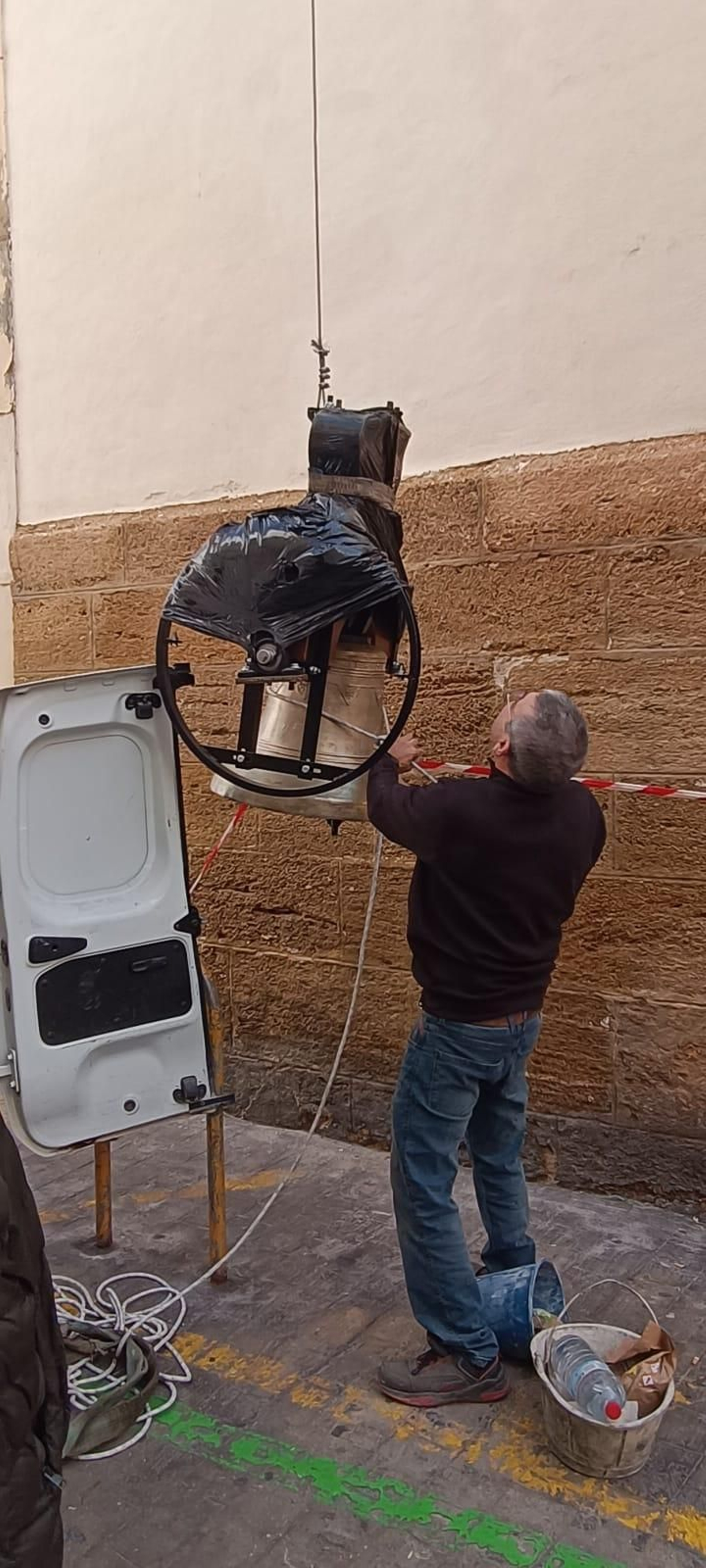 Uno de los operarios comienza la operación de izado de una de las campanas restauradas de la Merced.