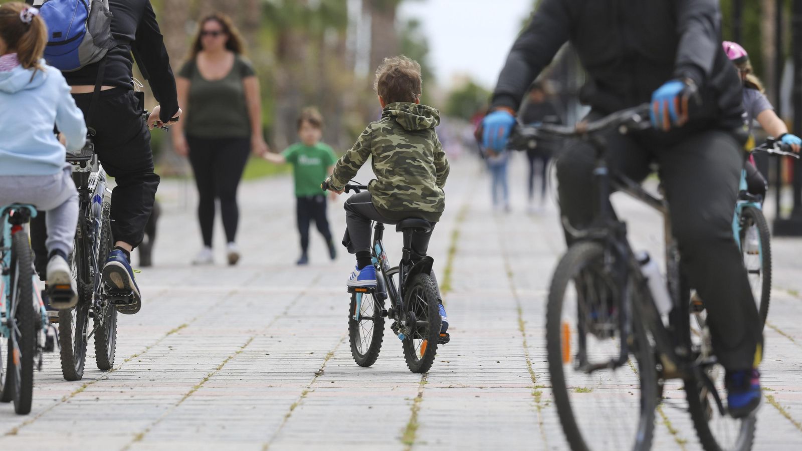 Niños pasean en bicicleta en sus primeras salidas tras el confinamiento.