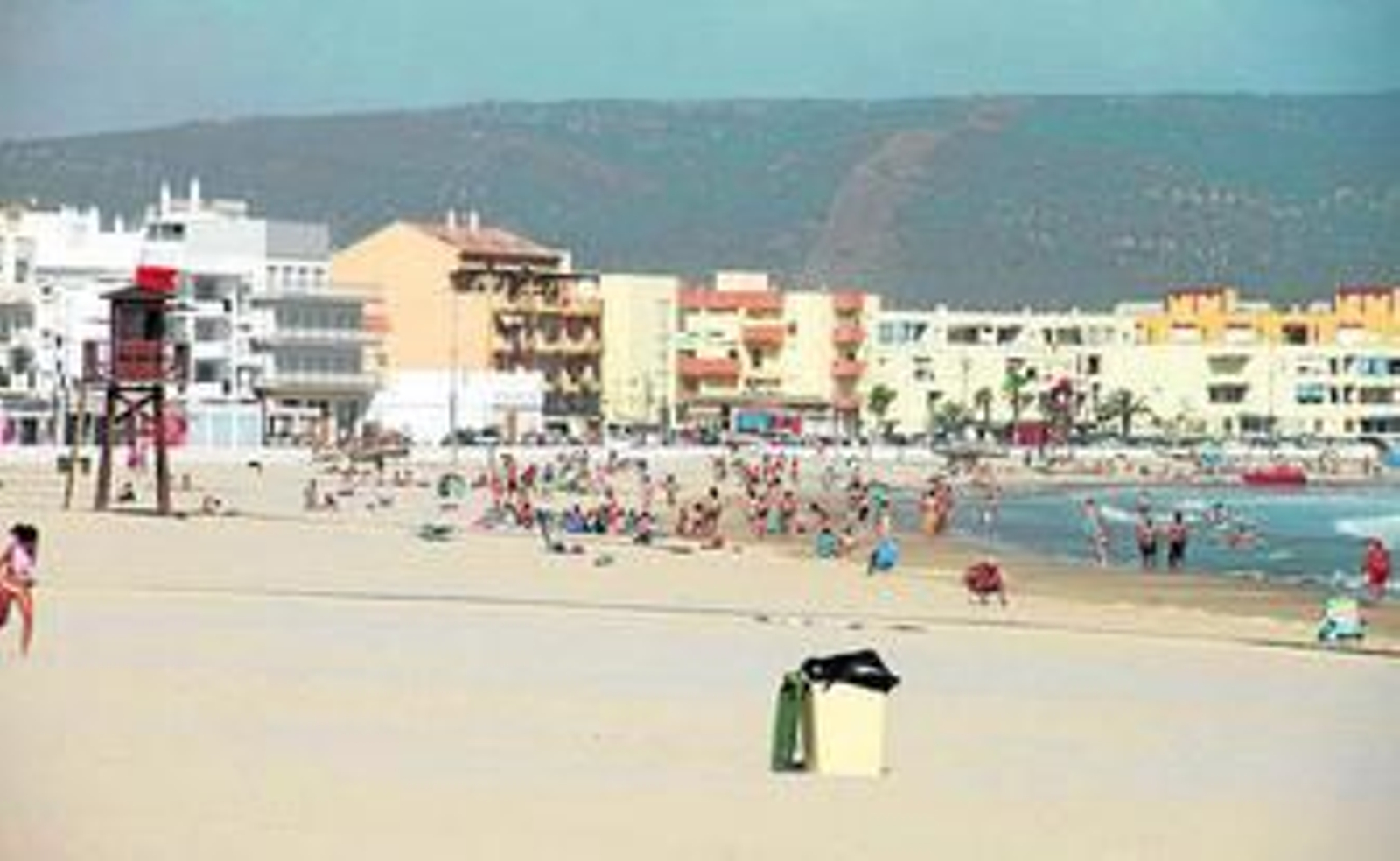 La playa del Carmen ayer, con bandera roja por el viento, pero con gente en el agua.