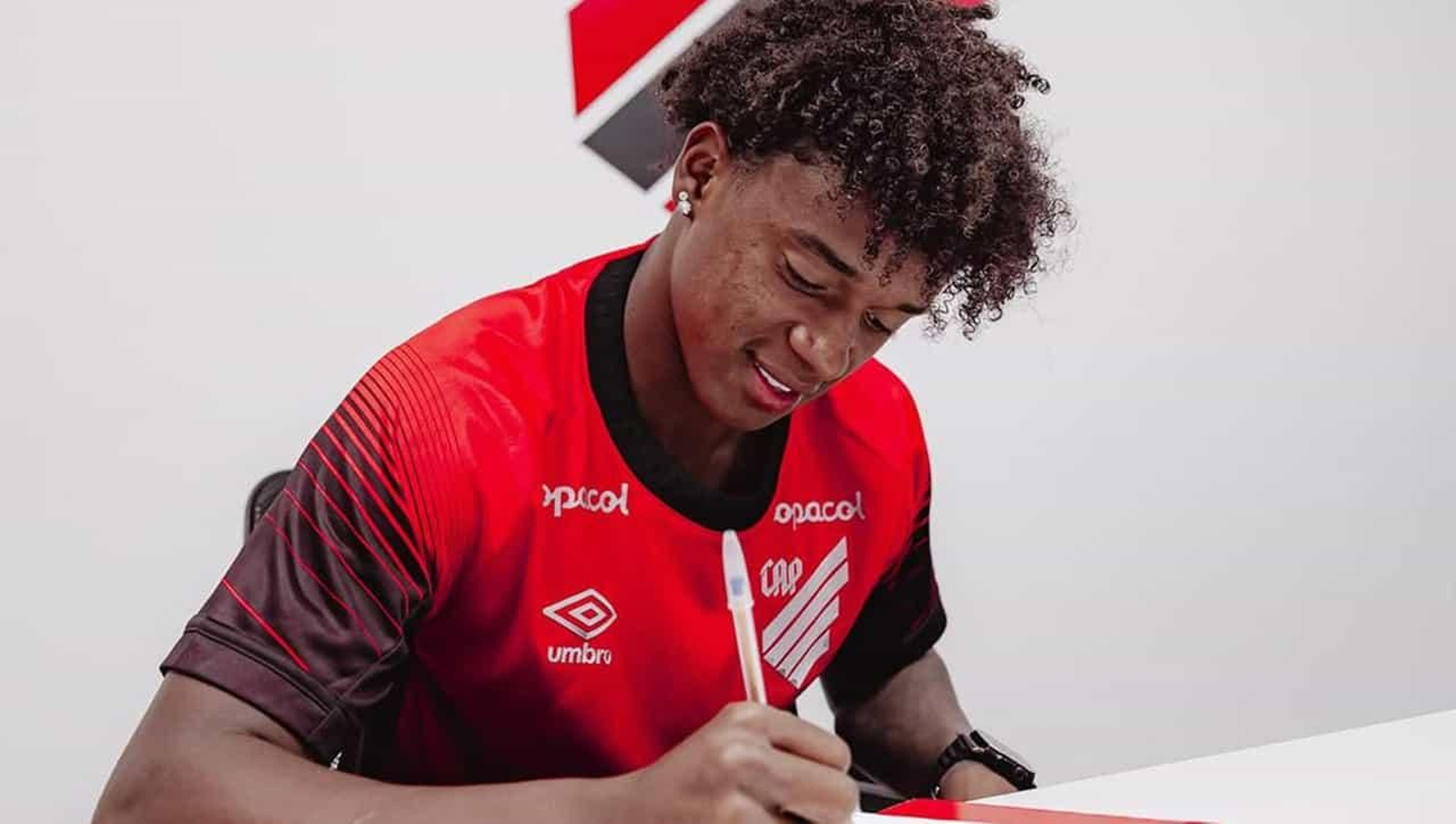 Bruninho firmando su contrato con Atlético Paranaense