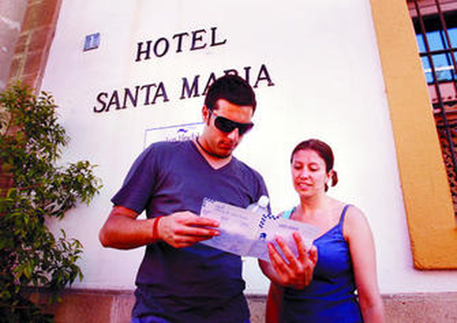 Dos turistas ingleses estudian un mapa de la ciudad a las puertas del céntrico hotel Santa María.