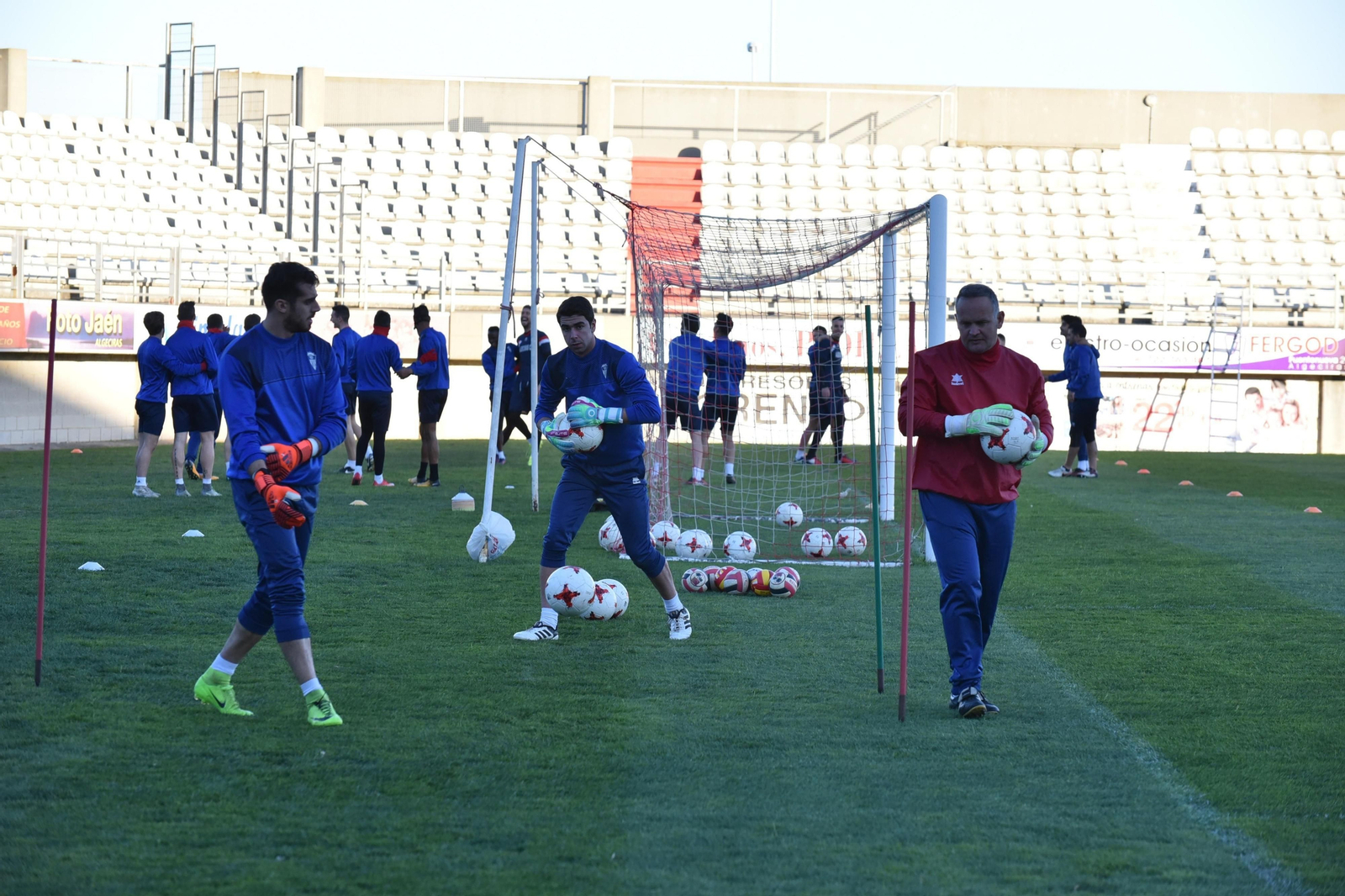 Pablo Barroso sujeta un balón entre Jesús Romero y el preparador de porteros, David Enríquez.