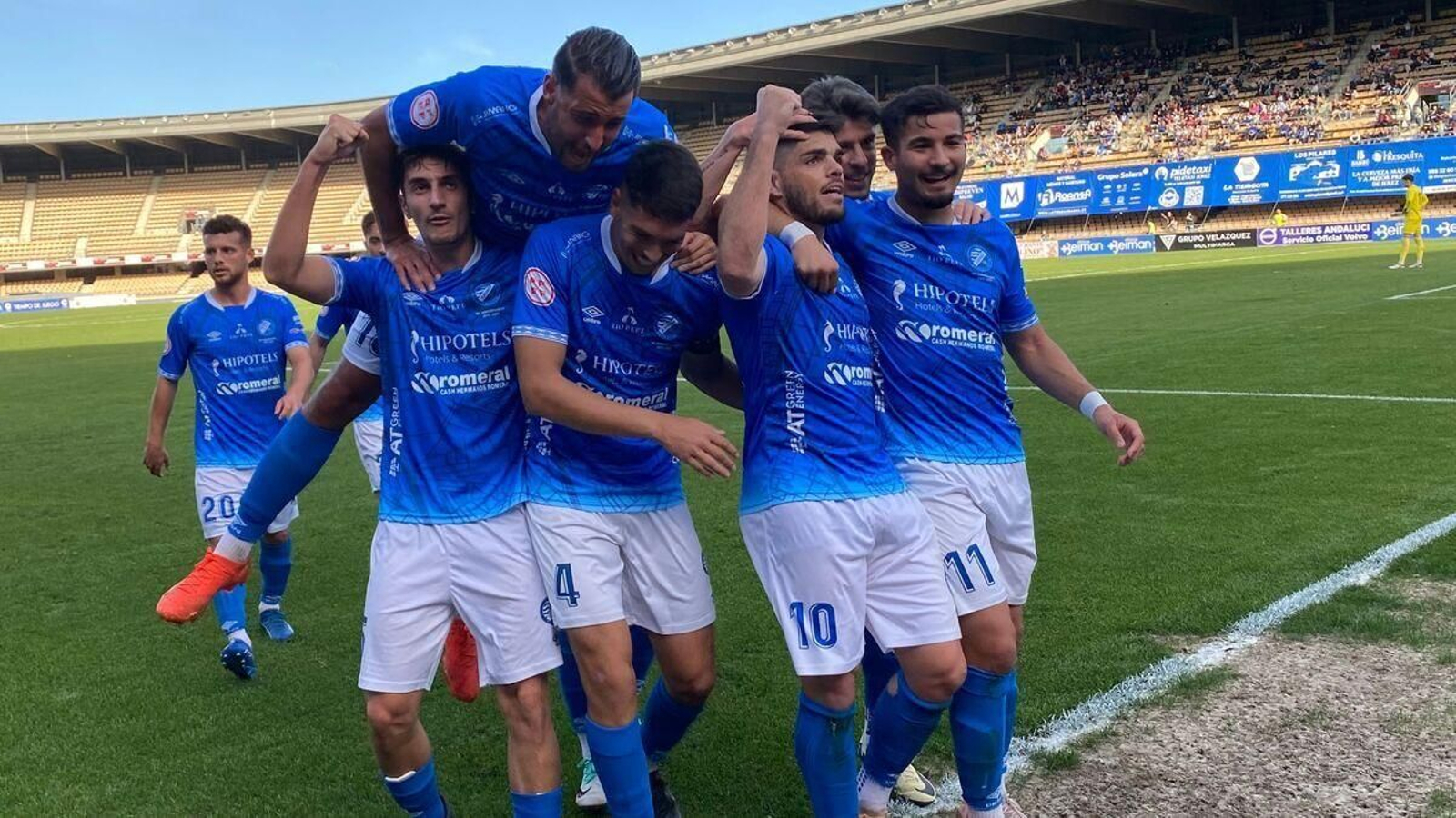 Los xerecistas abrazan a Carri tras anotar el 1-0 de penalti ante el Sevilla C en Chapín.