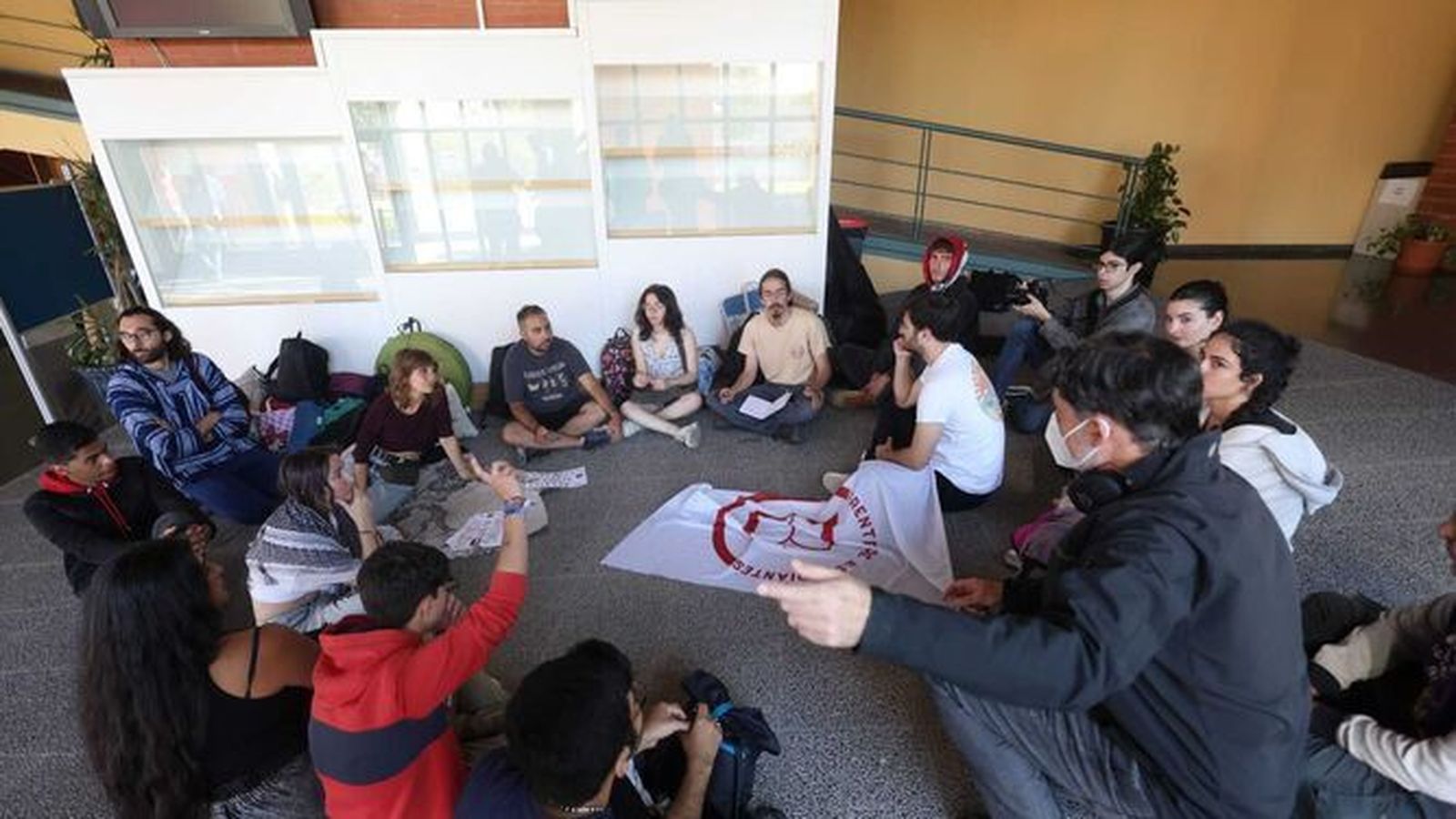 Estudiantes sentados en el suelo de la Biblioteca General de la UMA.