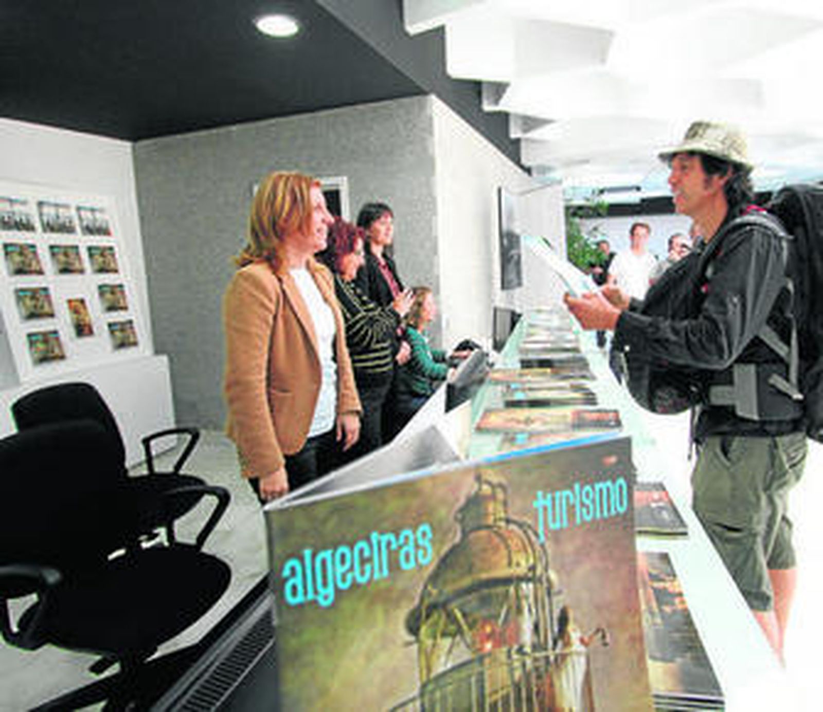 El primer visitante de la nueva oficina de turismo recoge ayer una guía de la ciudad.
