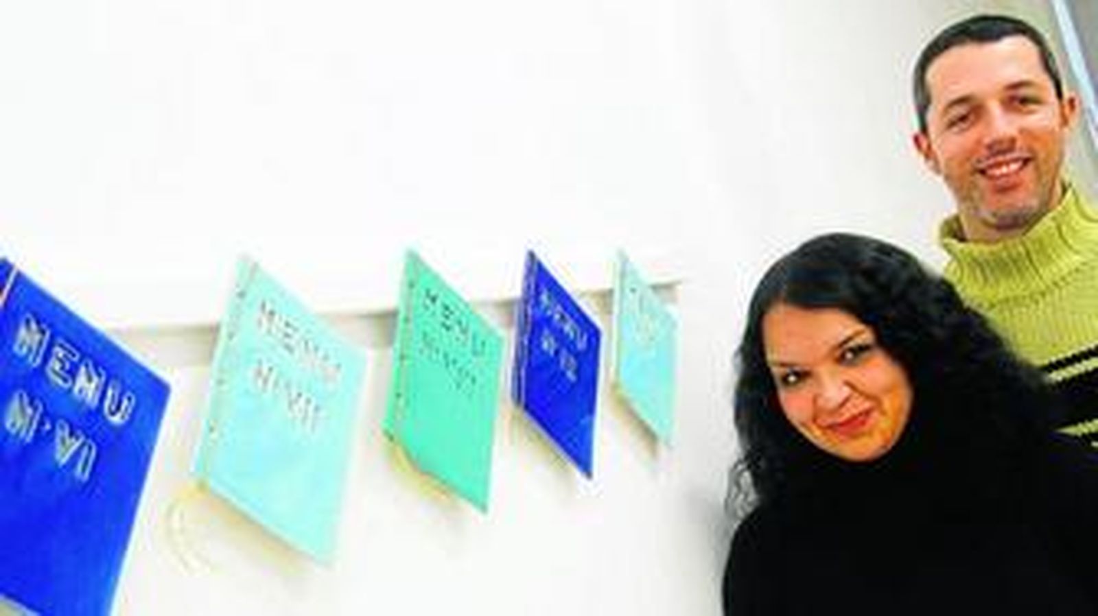 Los gaditanos Rocío Arévalo y Pablo Alonso de la Sierra, integrantes de Vendaval, junto a los menús del 'Banquete de los Tres Días'.