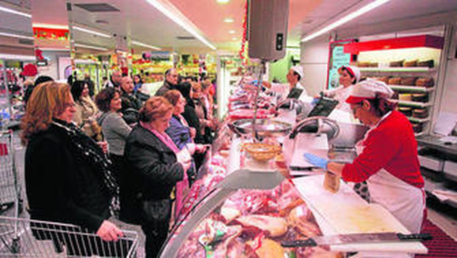 Los clientes hacen cola comprar la cena de Nochevieja, ayer en el supermercado Deza.