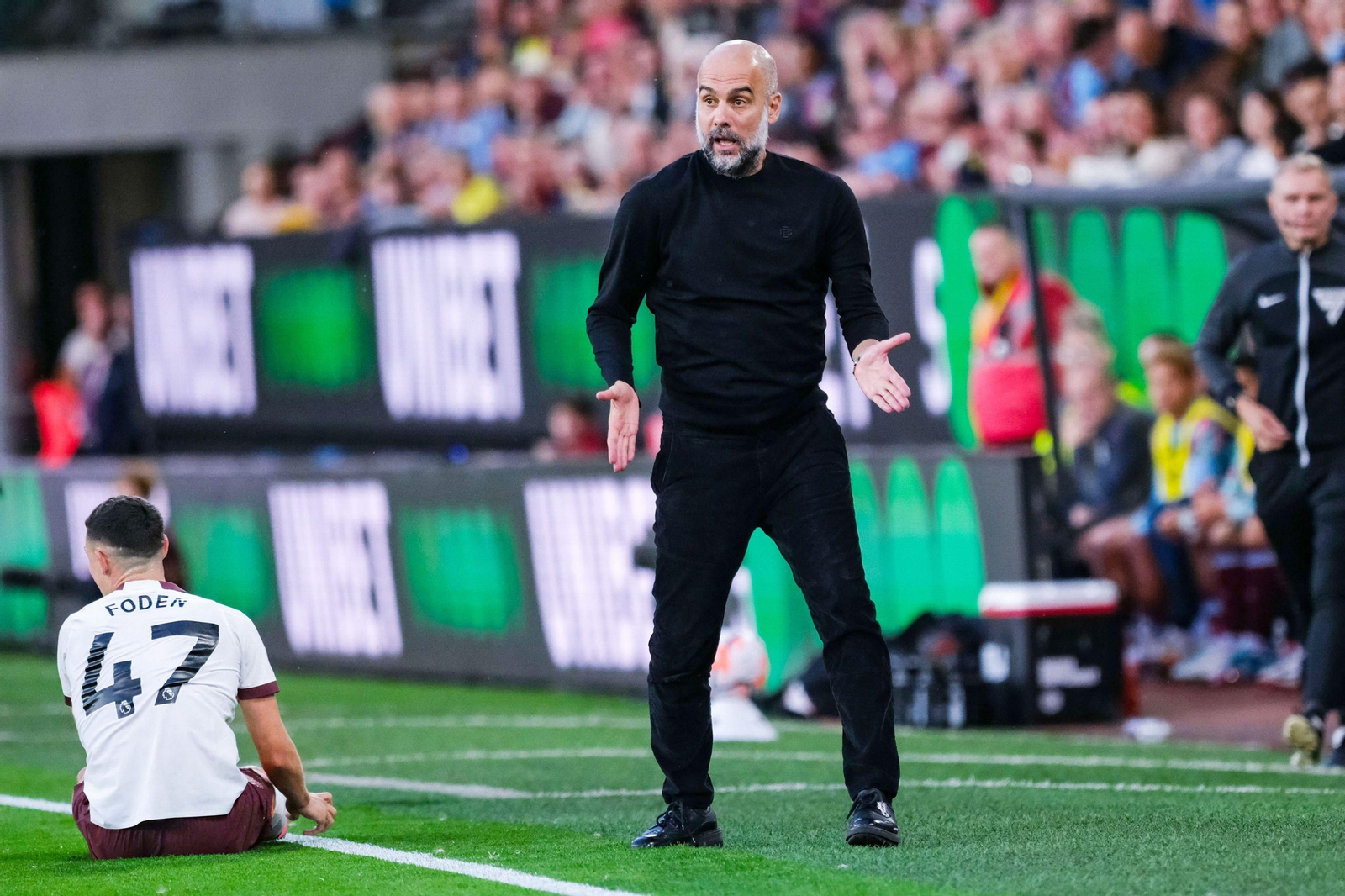Pep Guardiola, ante Foden, que sí está convocado, en el partido frente al Burnley.