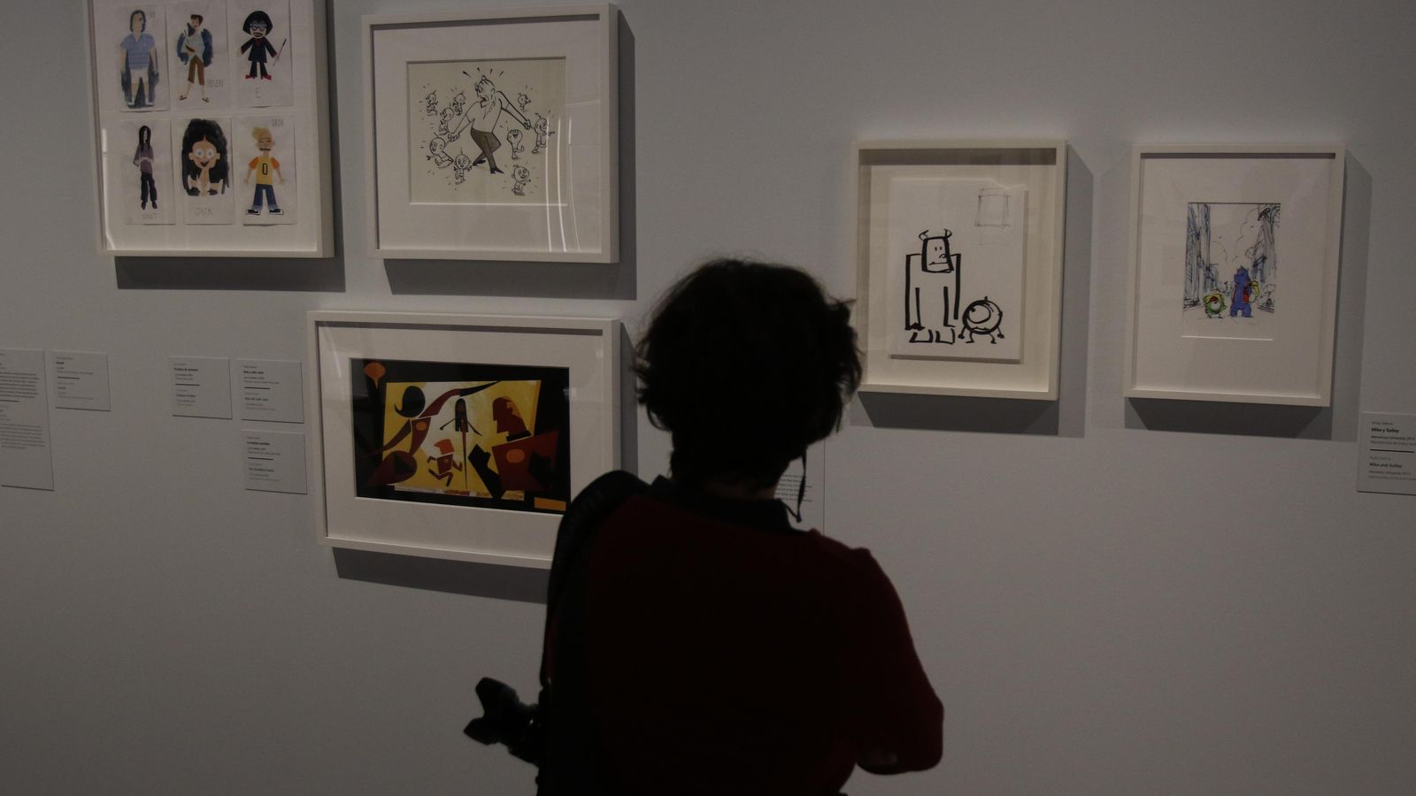 Una mujer contempla algunos bocetos creados para 'Monstruos, S.A.'.