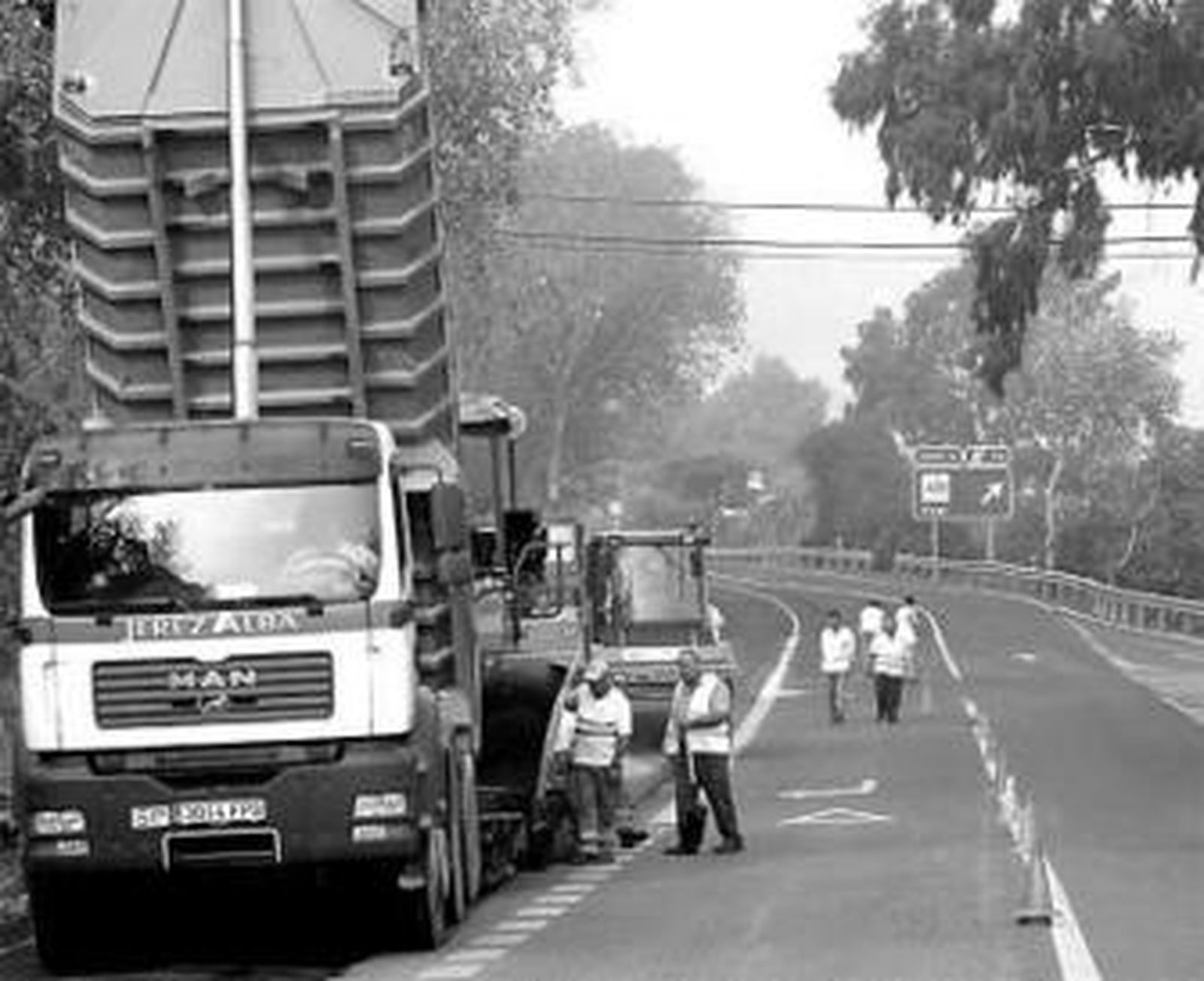 Operarios trabajan en el reasfaltado de la vía.