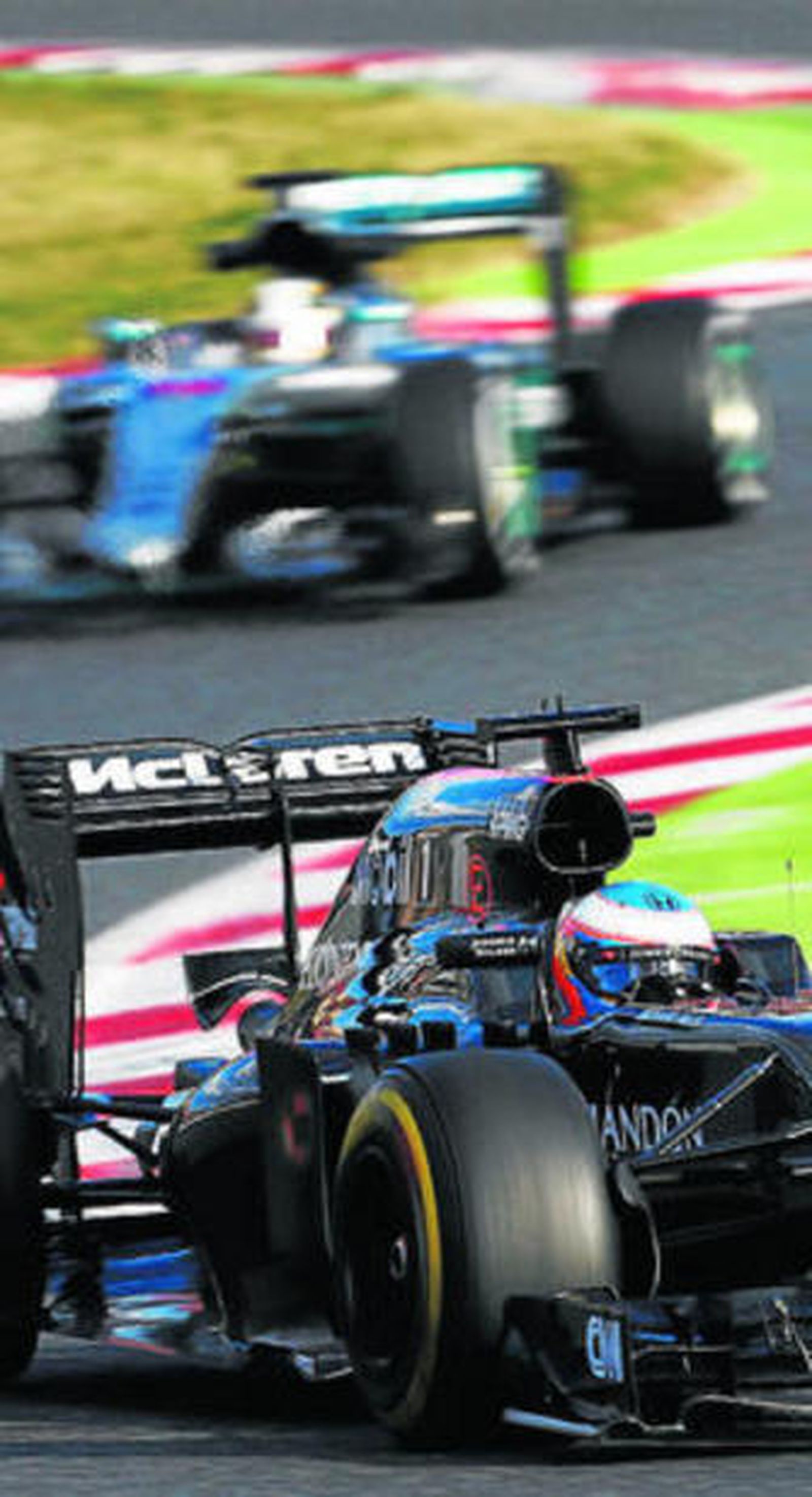 Fernando Alonso en plena preparación, con Hamilton en segundo plano.