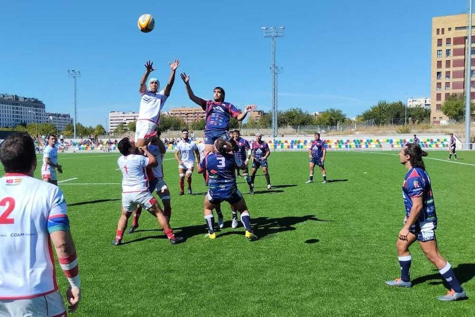 Jugadores de ambos equipos pelean por la disputa de un balón durante una acción del encuentro.