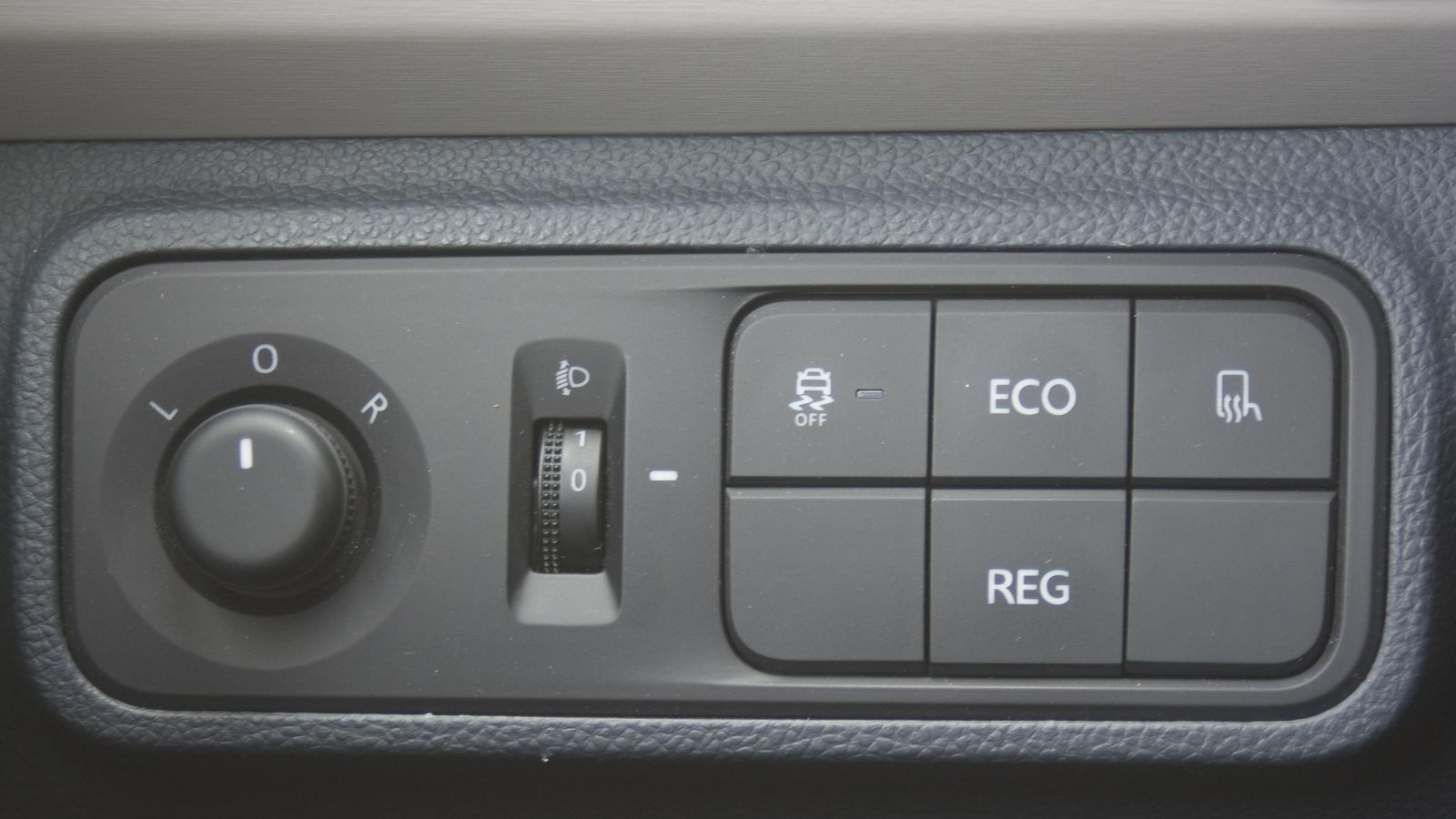 Entre el volante y la puerta se sitúan los mandos de regulación y calefacción de retrovisores, el desconexión del ESP o los de la selección de nivel de frenada regenerativa y función Eco.